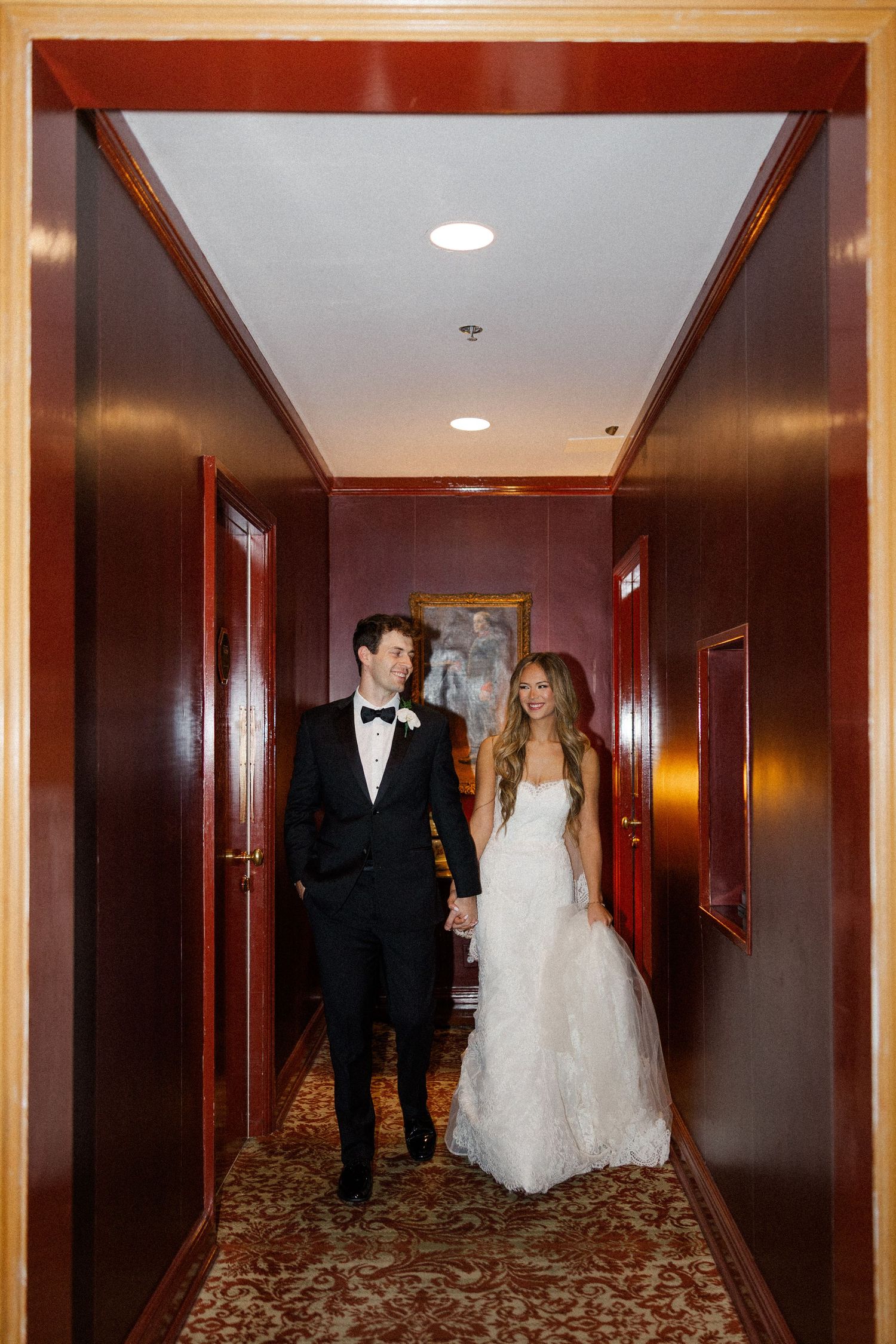 A couple walks down an elegant hotel hallway with wood paneling and patterned carpet in a sequence of photos.