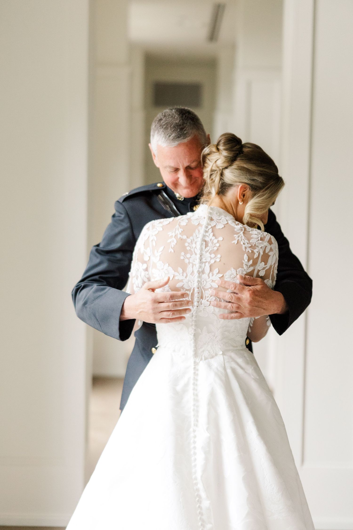 Emotional first look moment between bride in lace gown and loved one.