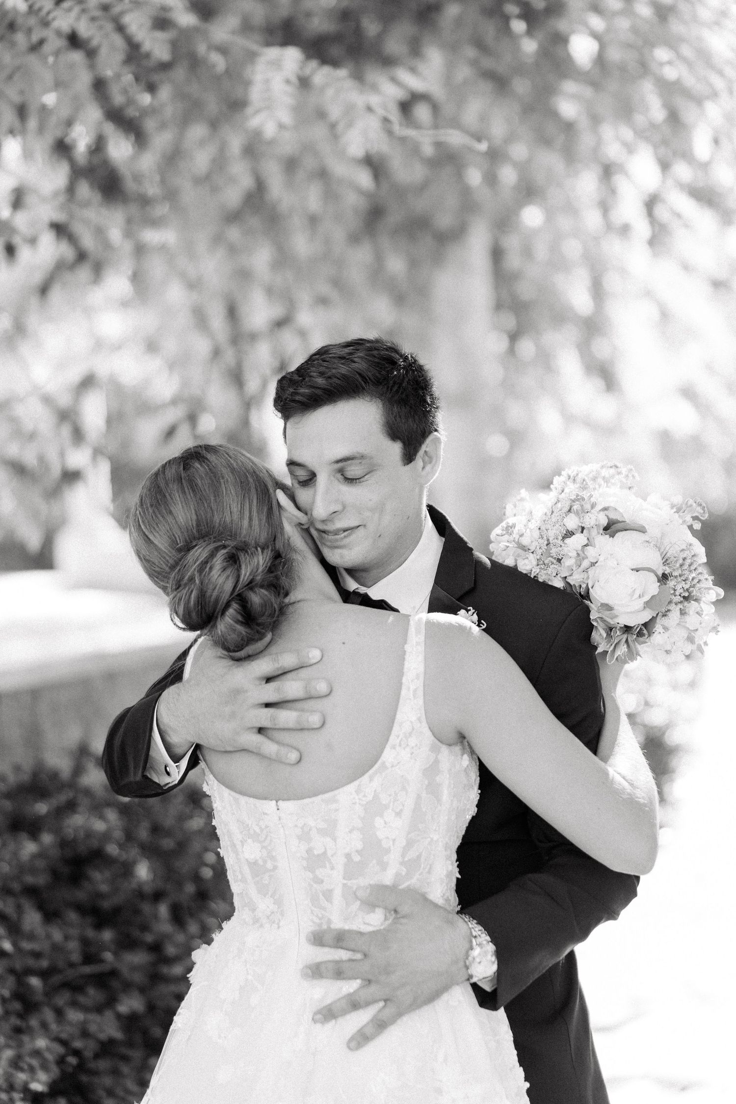 A romantic black and white wedding photo series showing tender moments between newlyweds in an outdoor setting.