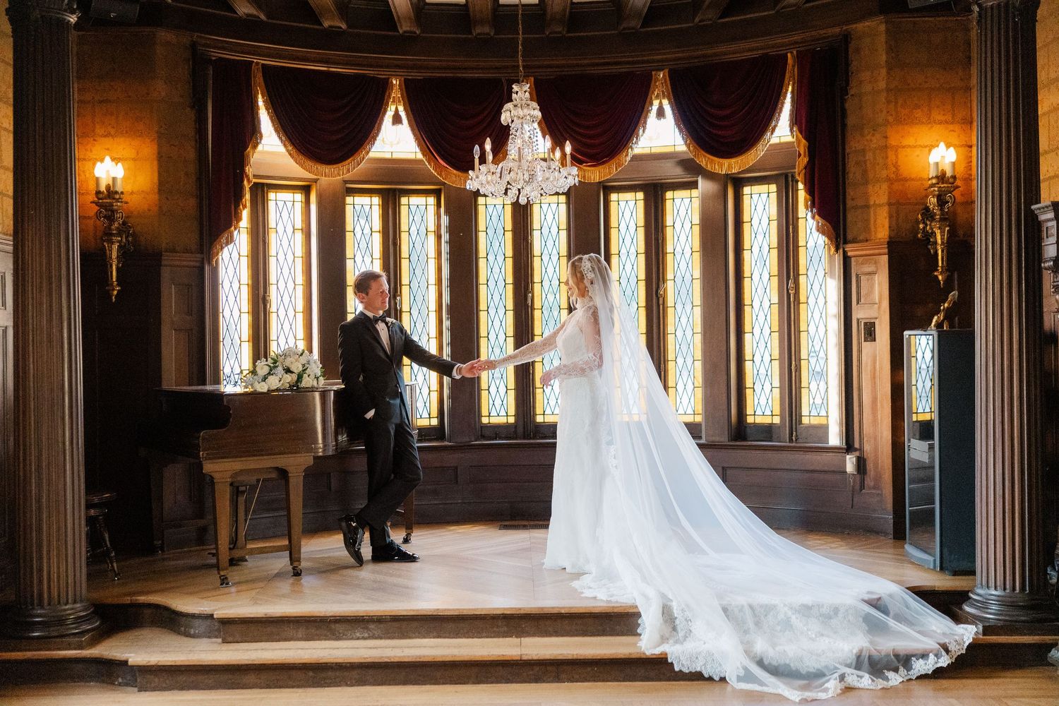 Interior shots of a grand historic venue with columns and archways decorated for an elegant wedding.
