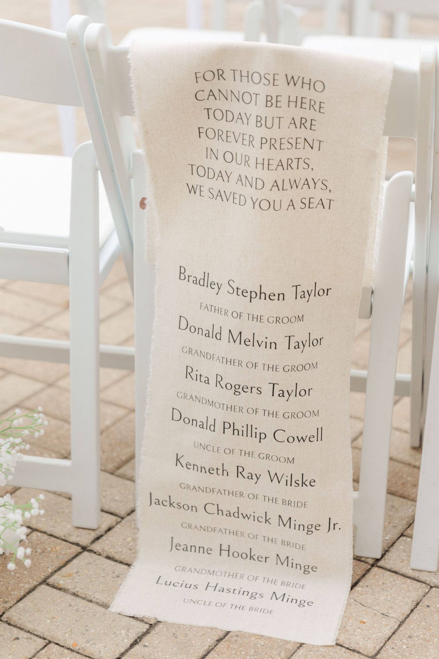 Memorial sign at wedding ceremony listing loved ones who cannot be present.
