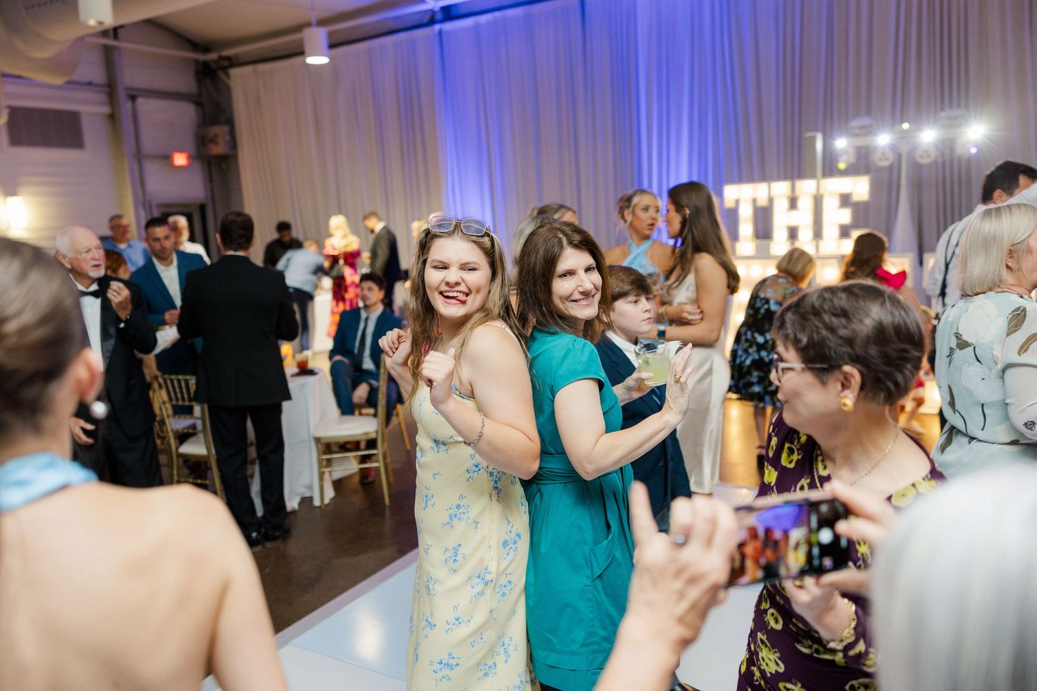 Wedding reception dance party with blue uplighting and white draping.