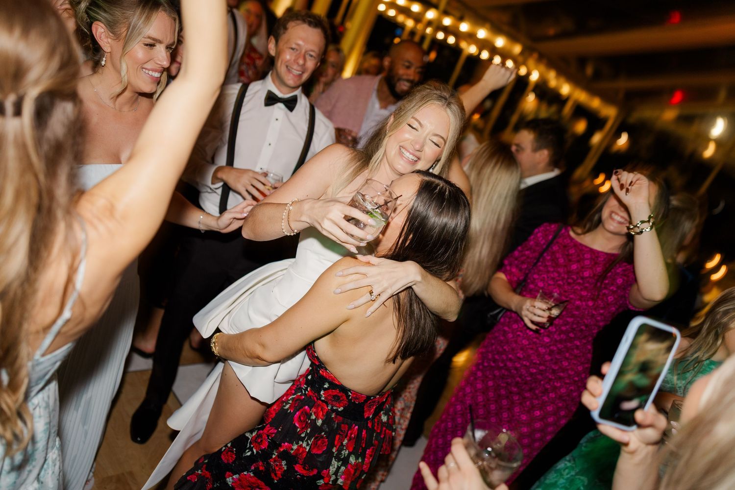 Wedding guests dance and celebrate on a lively reception dance floor.