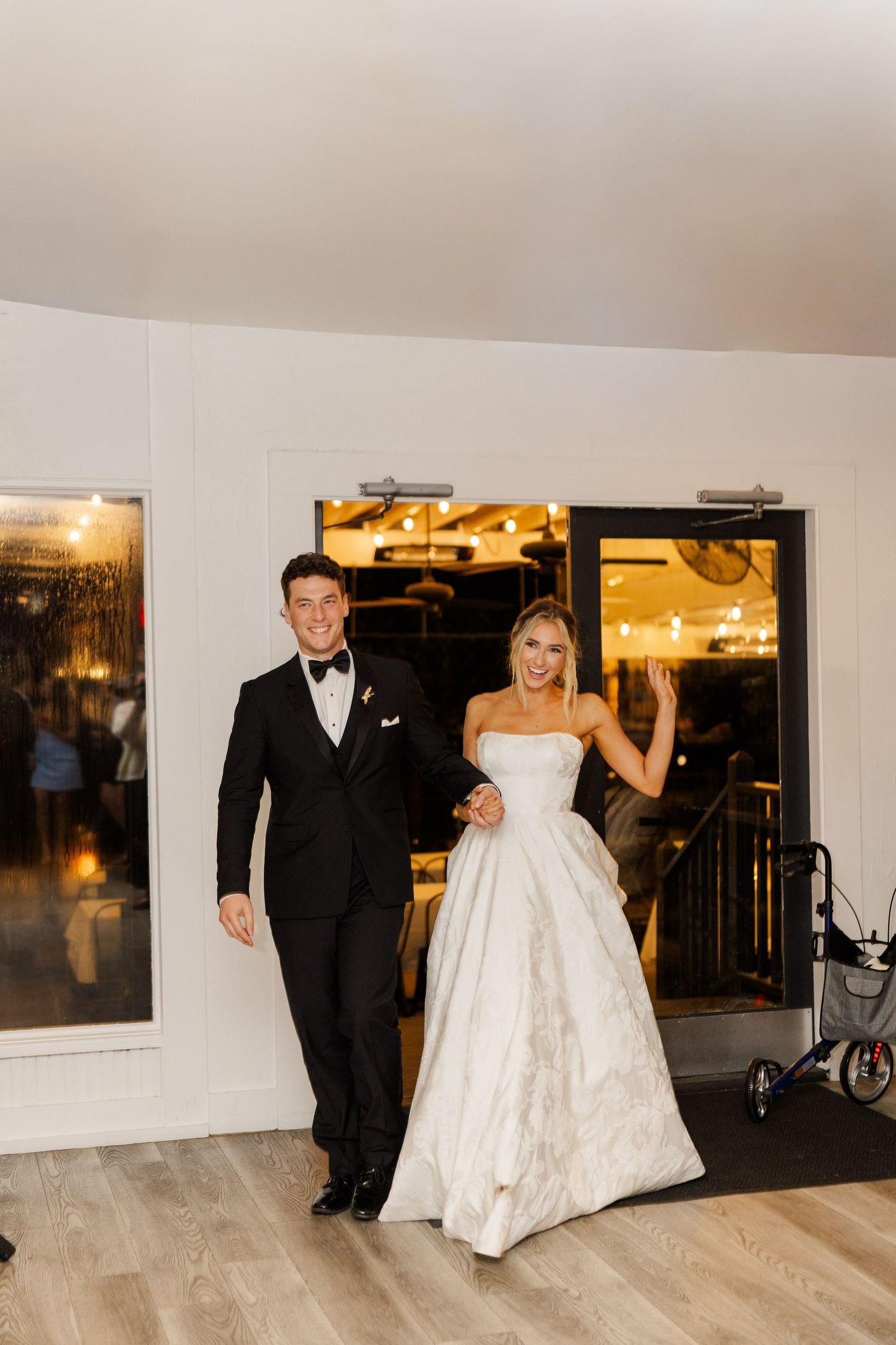 A couple makes their grand entrance at their wedding reception in formal attire.