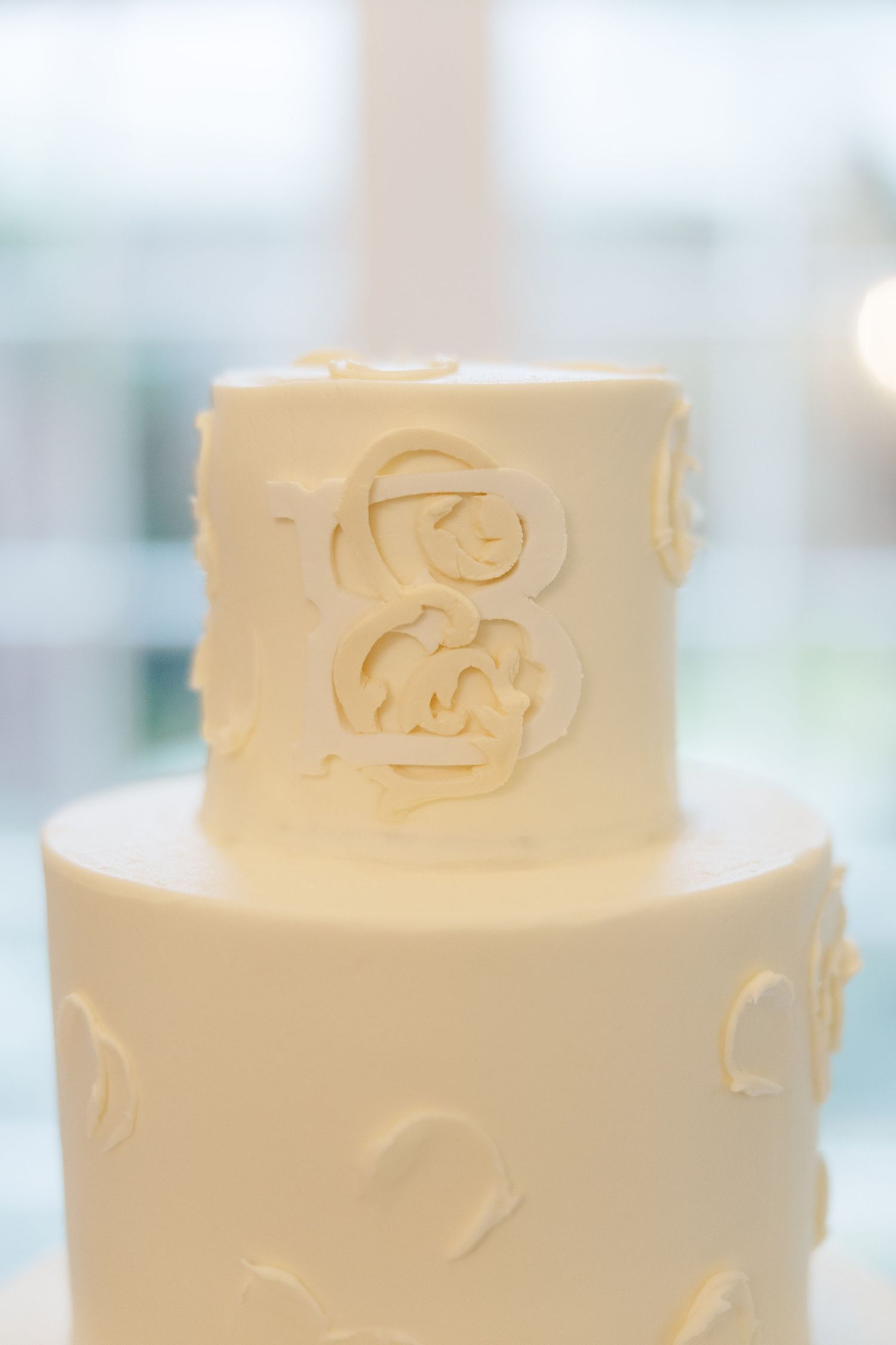 Elegant white wedding cake with delicate embossed floral design patterns on multiple tiers.