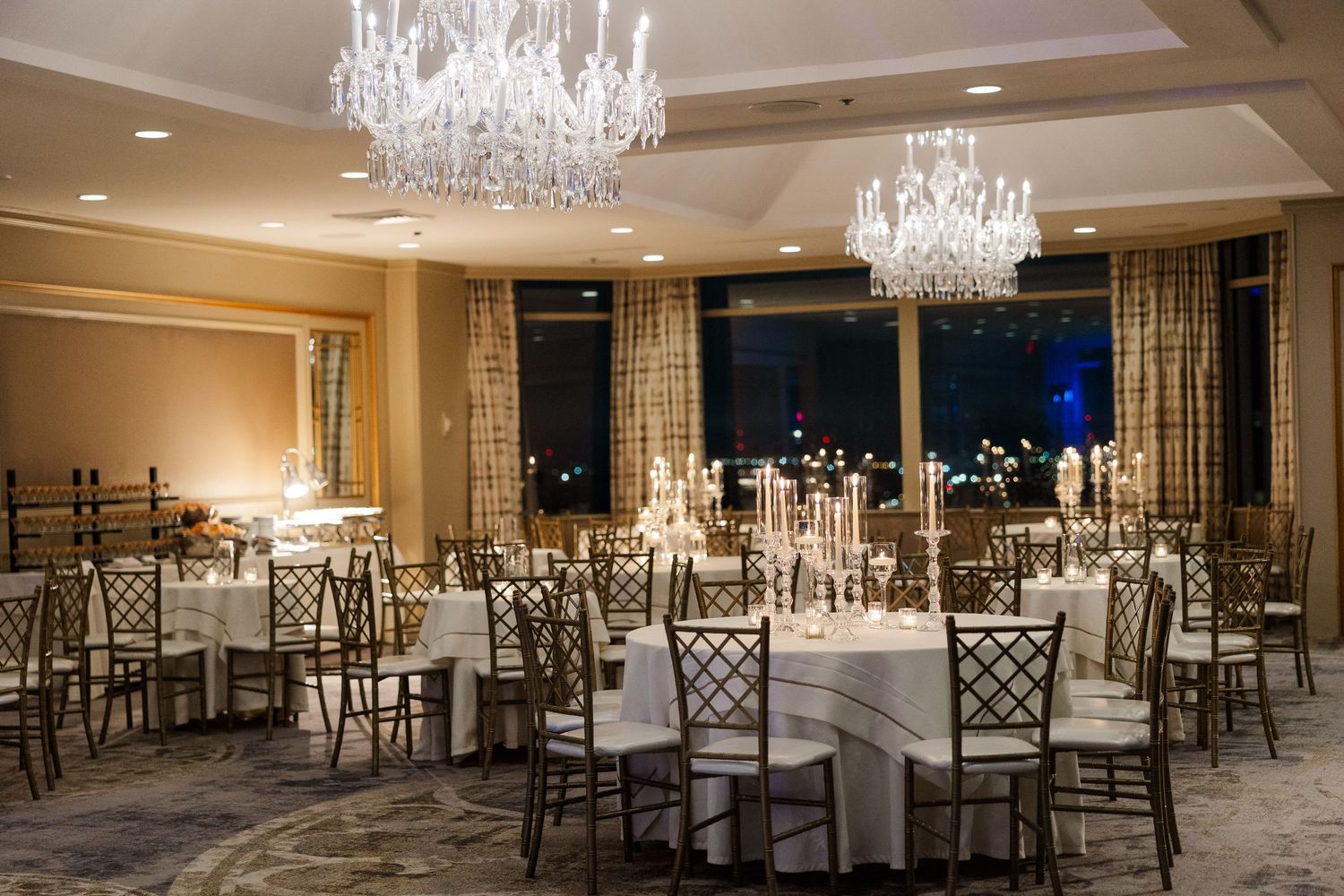 Luxurious wedding reception venue with crystal chandeliers and formal table settings.