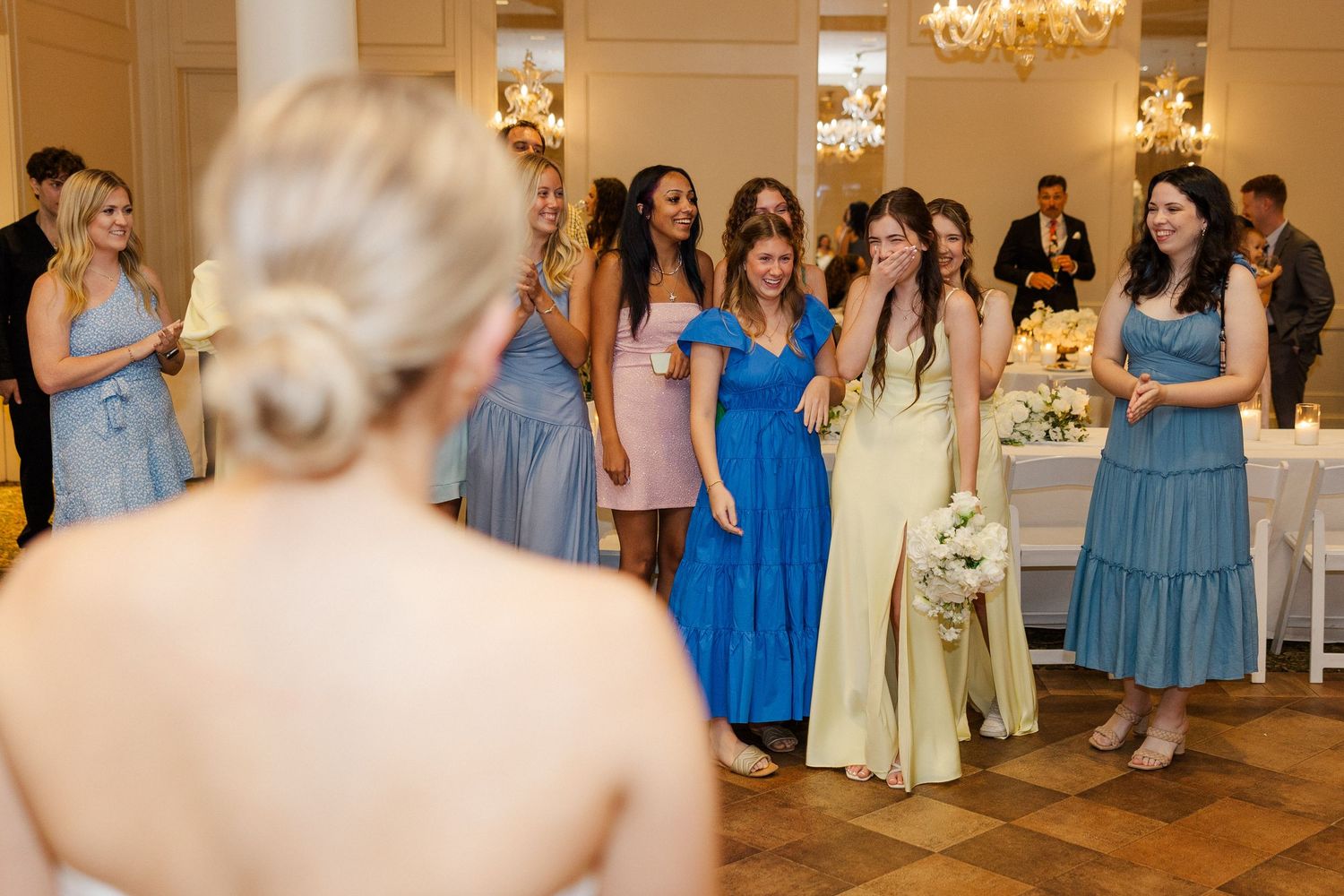 Wedding reception celebration with guests in blue and formal attire in an elegant venue.