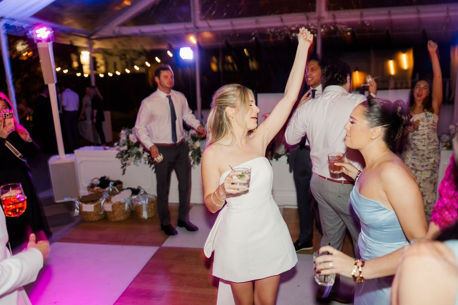 Wedding reception dance floor with festive lighting and guests celebrating.