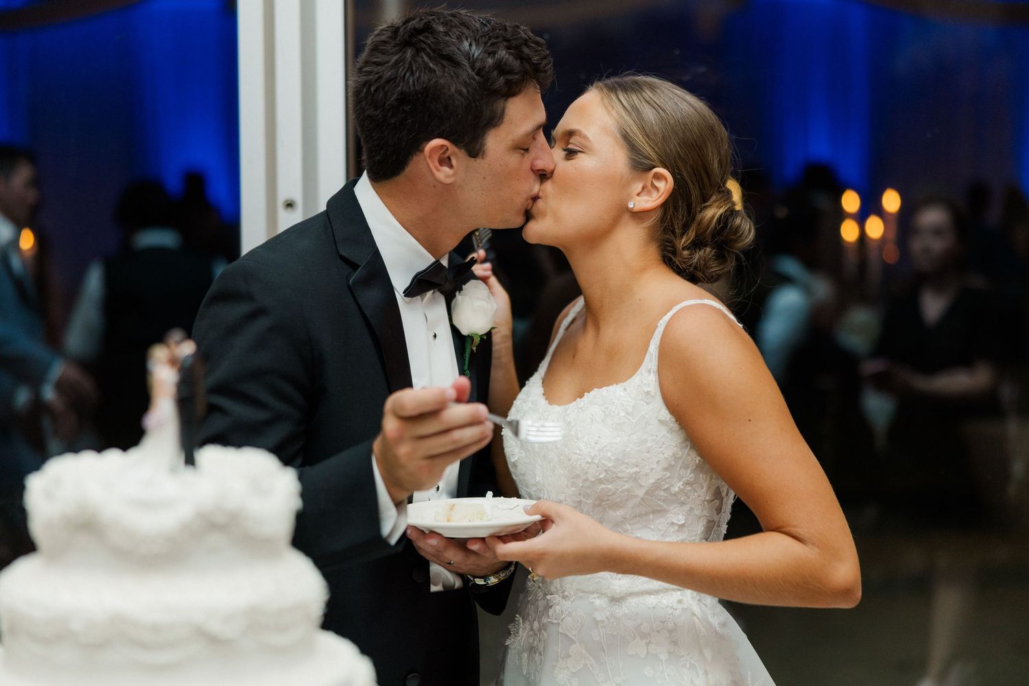 Wedding couple shares intimate moments while cutting and feeding each other cake.