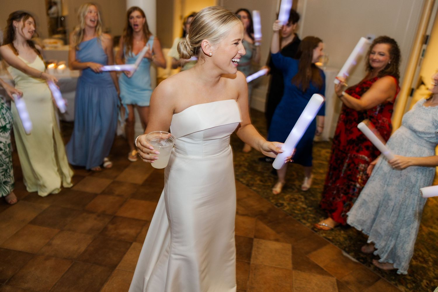 Wedding reception dance floor filled with guests celebrating and dancing.