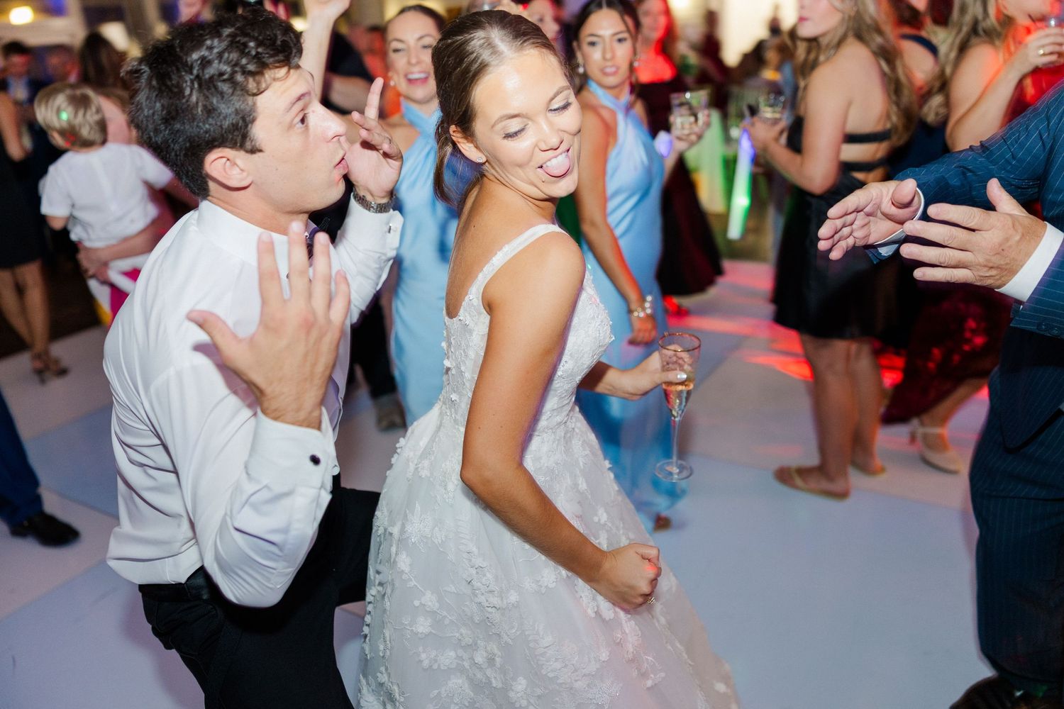 Wedding guests dance and celebrate on the dance floor during an evening reception.