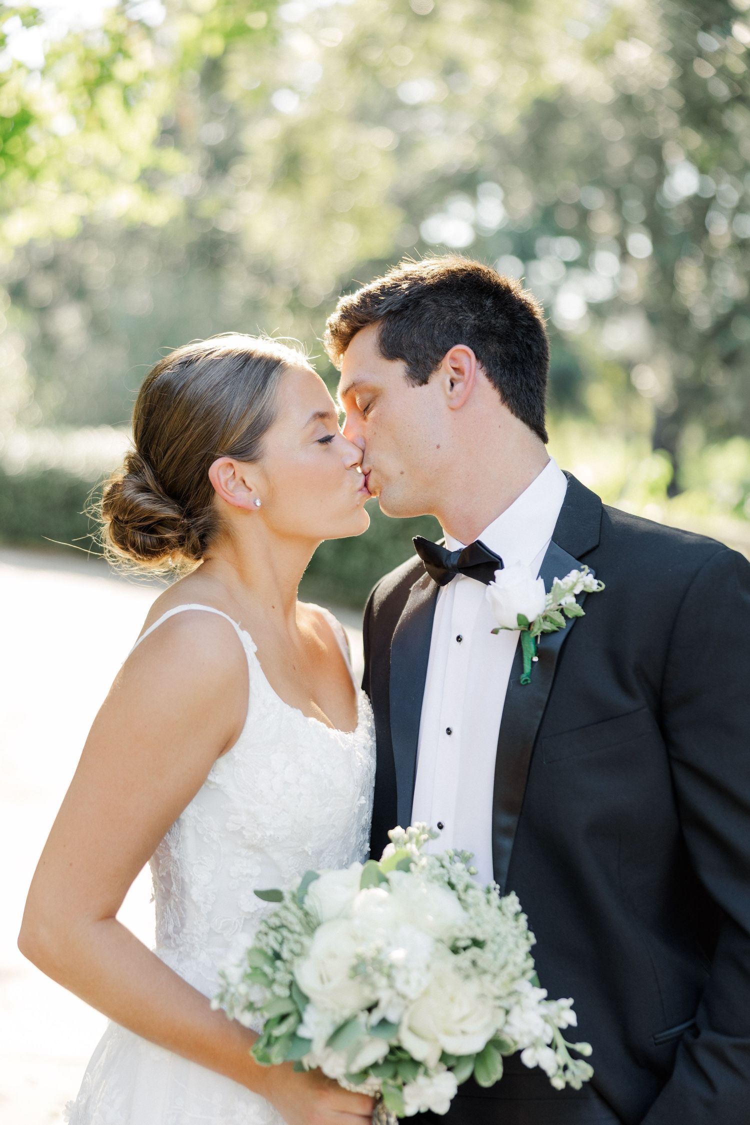 Romantic close-up of a couple sharing a tender moment with white floral bouquet.