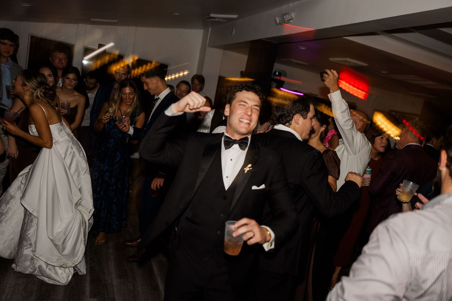 Wedding reception dance floor filled with guests celebrating and dancing.
