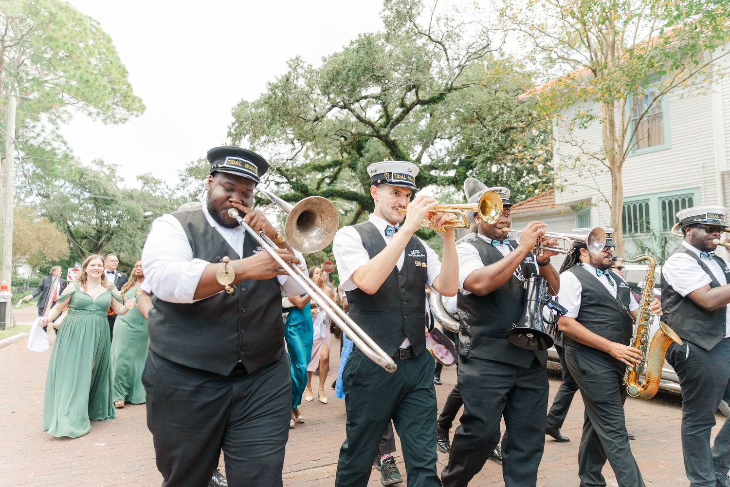 New Orleans jazz band wearing matching black and white uniforms performs in a street parade.