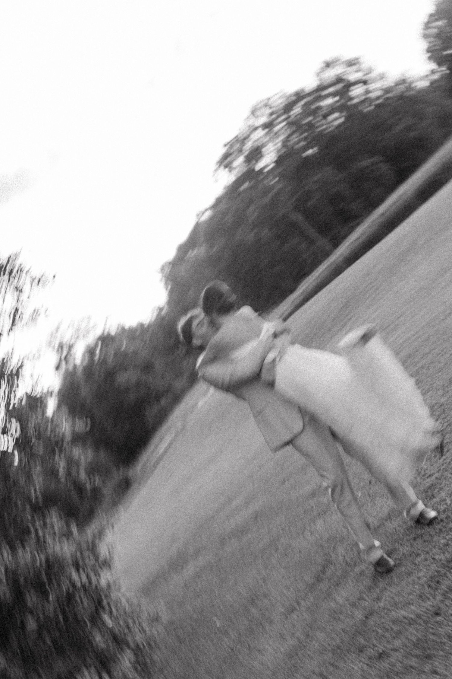 Artistic blurred black and white photo of bride and groom kissing outdoors on their wedding day.