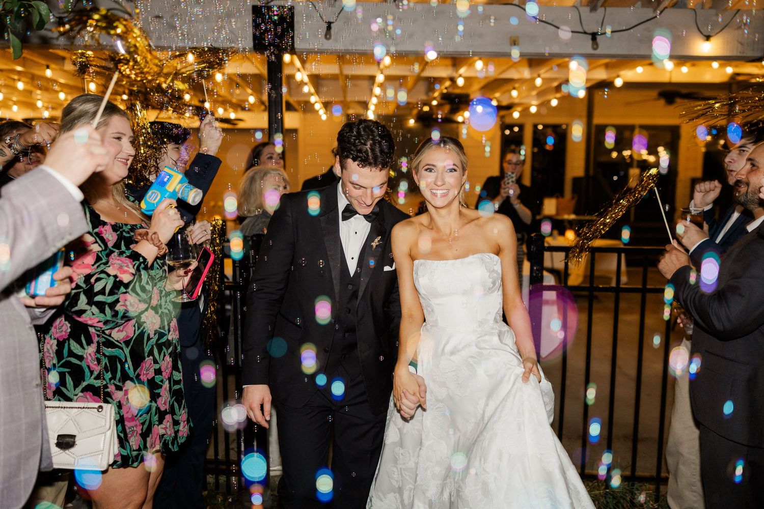 Festive wedding party celebration with confetti and dancing under golden lights.