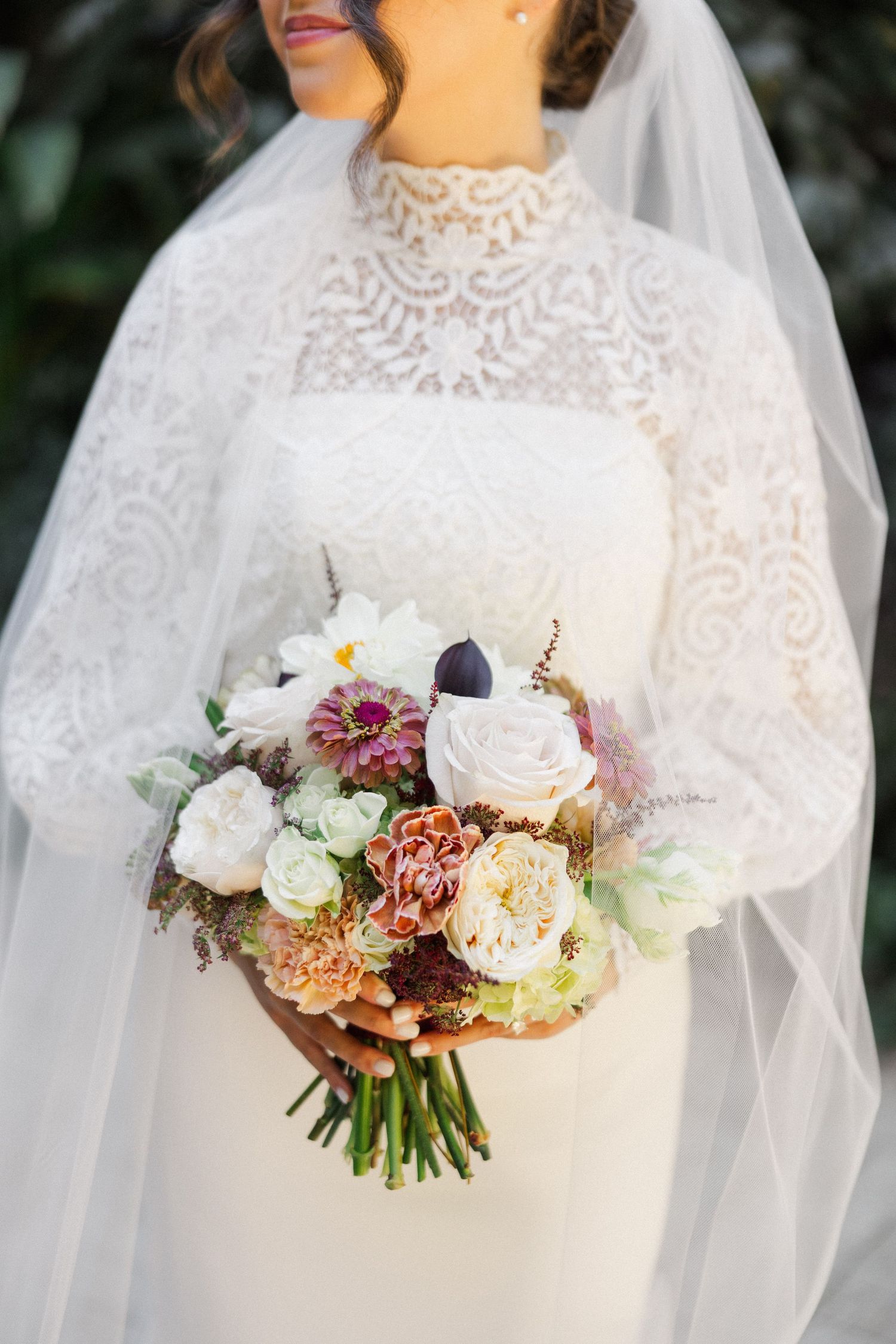 Close-up detail shots of a bridal bouquet with white, pink, and burgundy flowers wrapped in delicate lace veil.