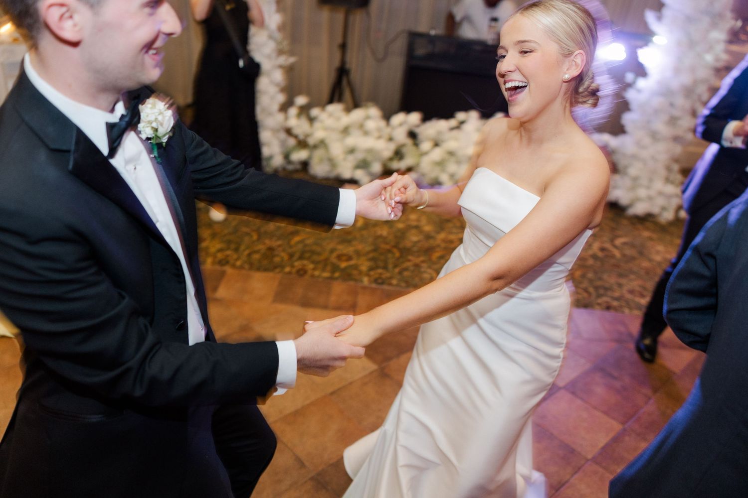 Joyful wedding dance sequence capturing movement and laughter on an elegant ballroom floor.