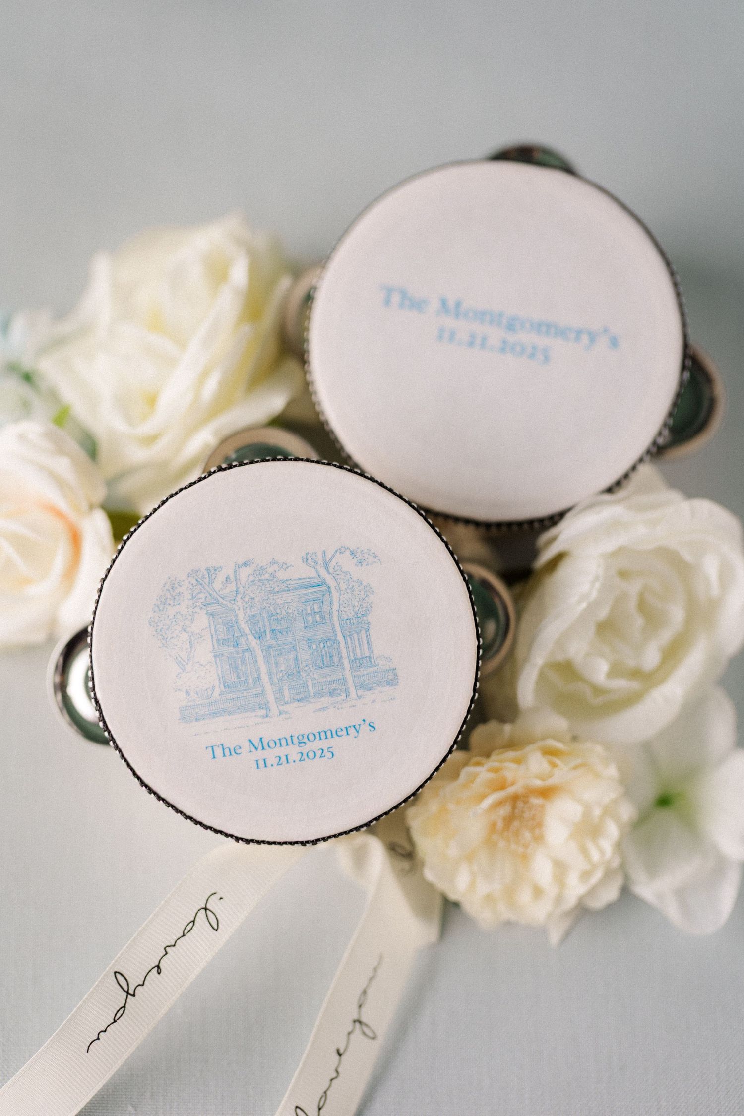 Elegant white paper fans with blue text and delicate white flowers arranged for a wedding celebration.