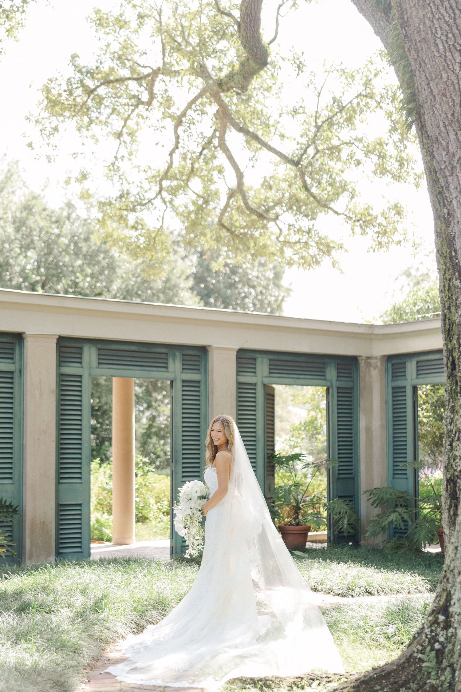Wedding photos in a garden setting with green shutters and white columns creating a romantic atmosphere.