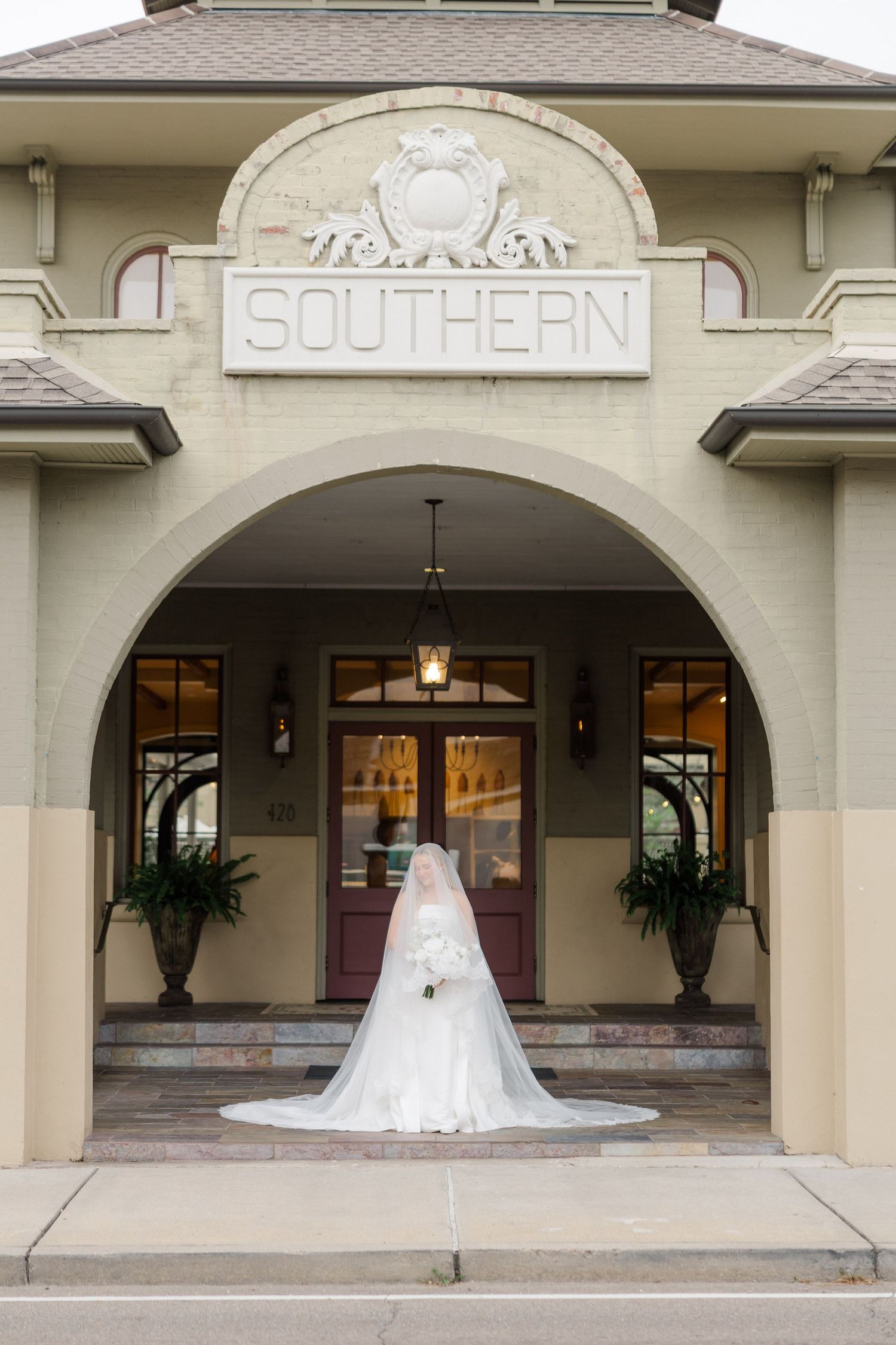 Elegant wedding venue exterior with cream colored archways and columns in a classic architectural style.