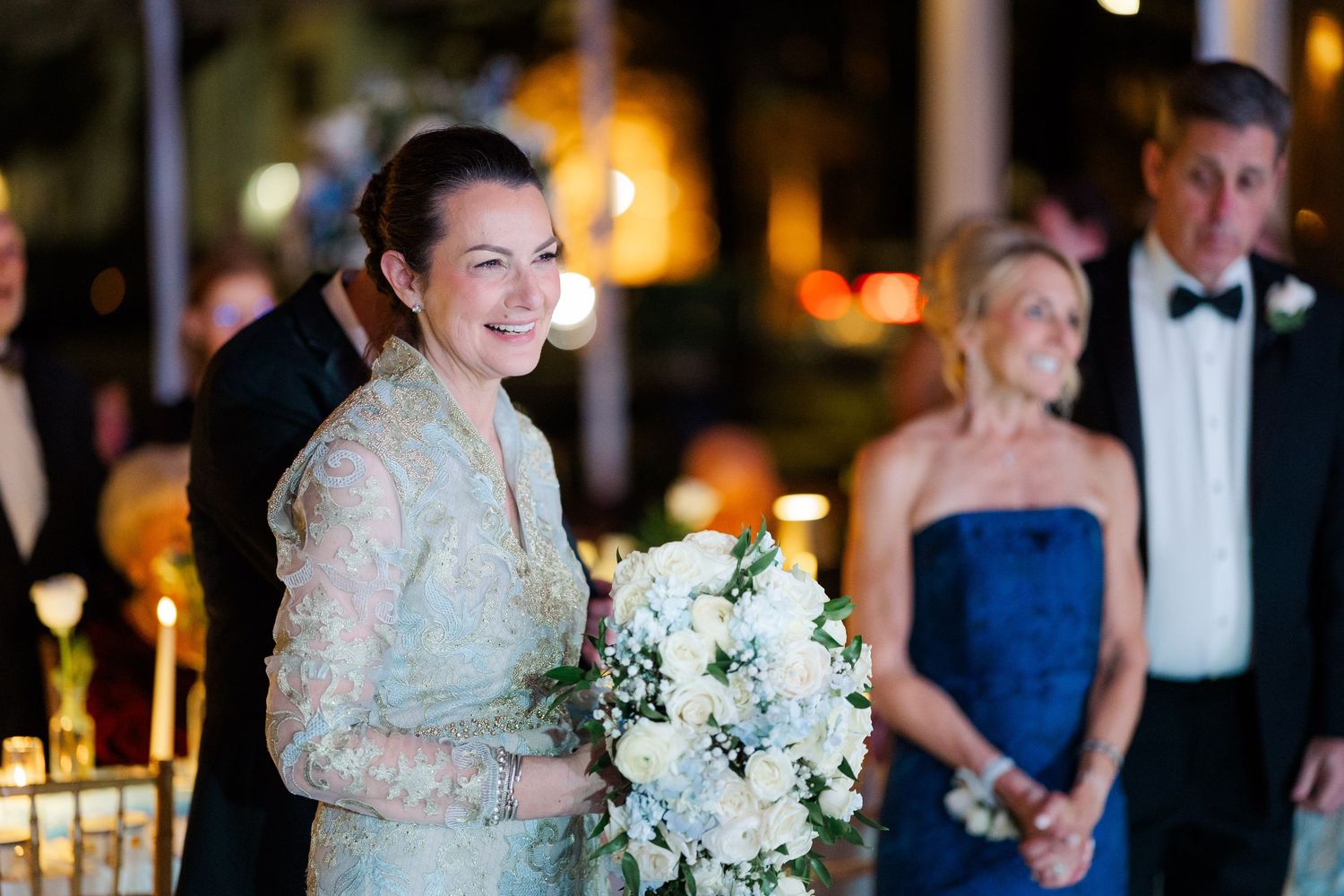 Wedding reception celebration with guests dancing under warm lighting.