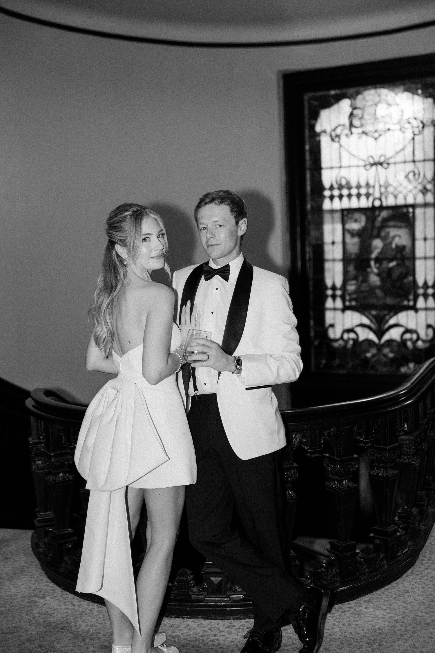 Black and white photo of couple sharing intimate moment on vintage staircase.