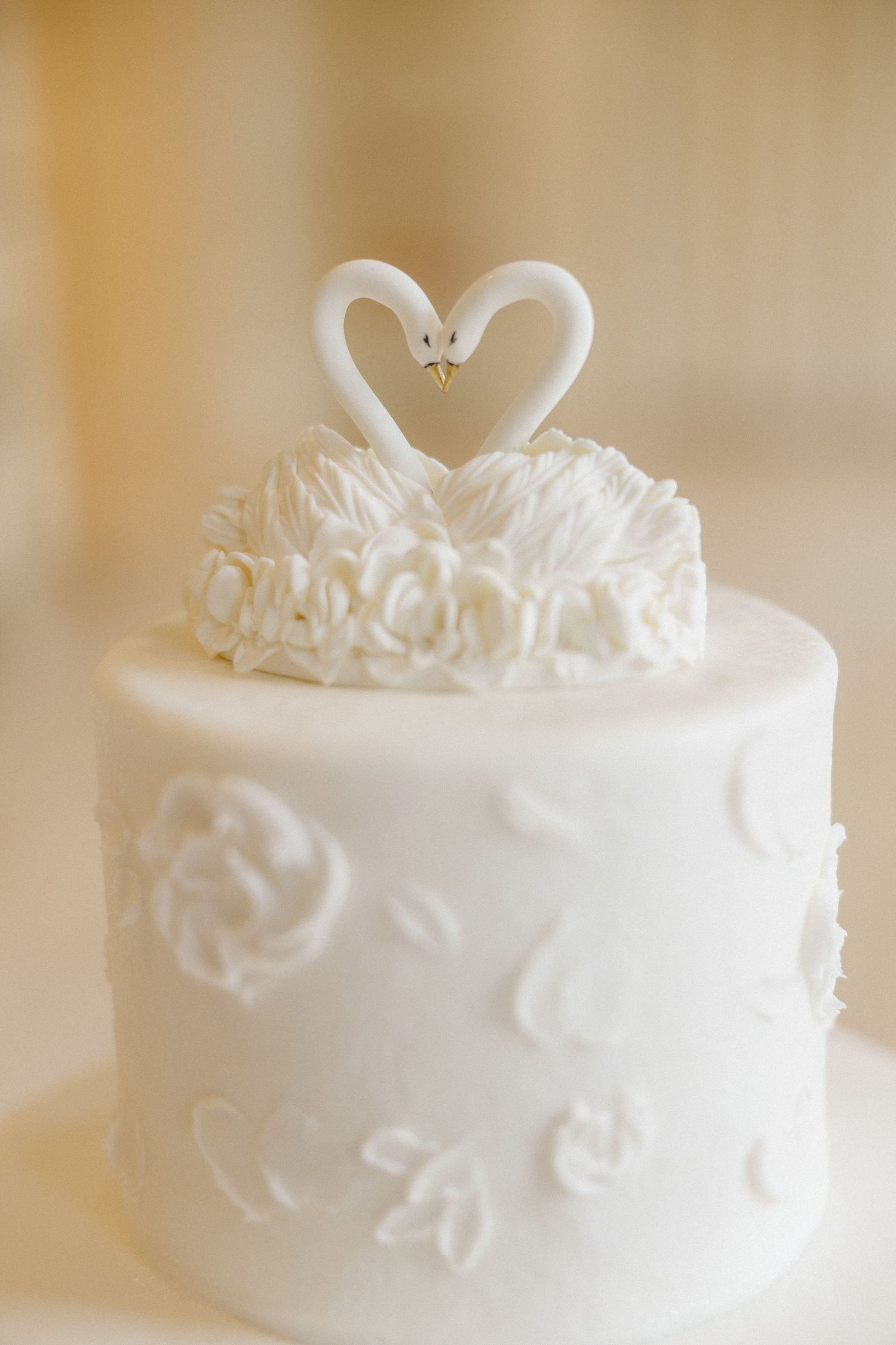 White wedding cake decorated with delicate floral patterns and lace details displayed in multiple angles.