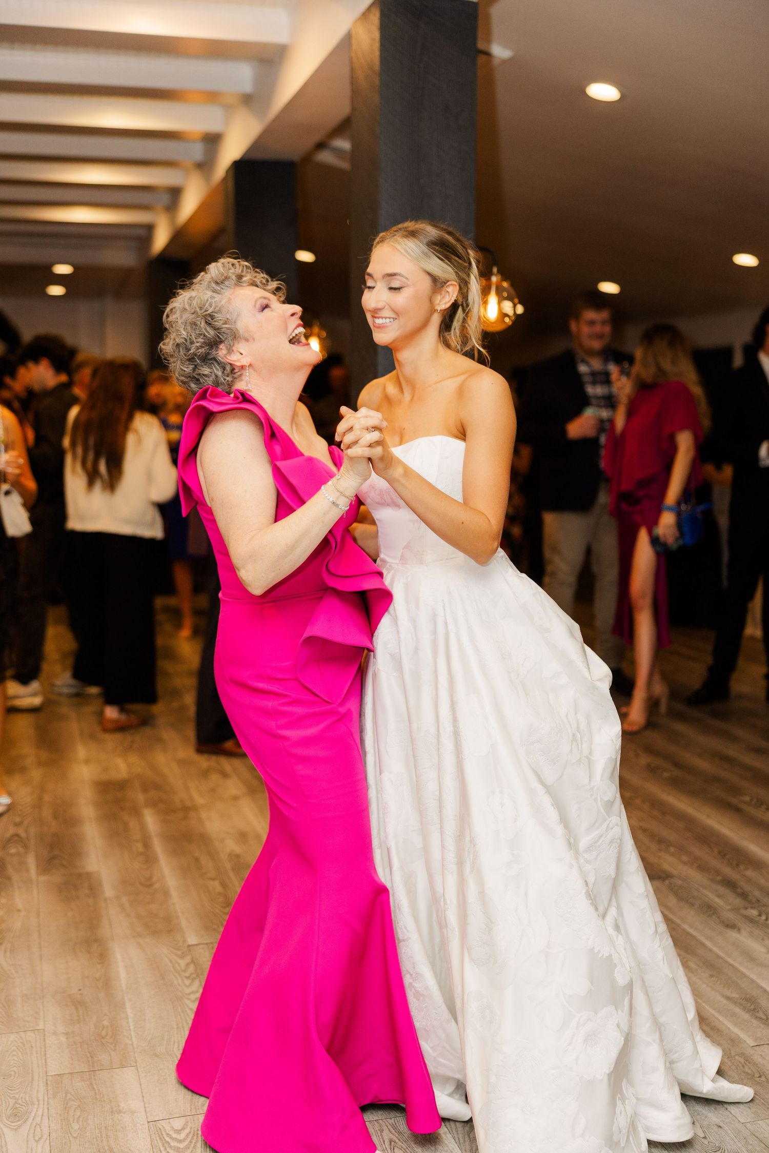 A heartwarming dance between two wedding guests, one in pink and one in white.