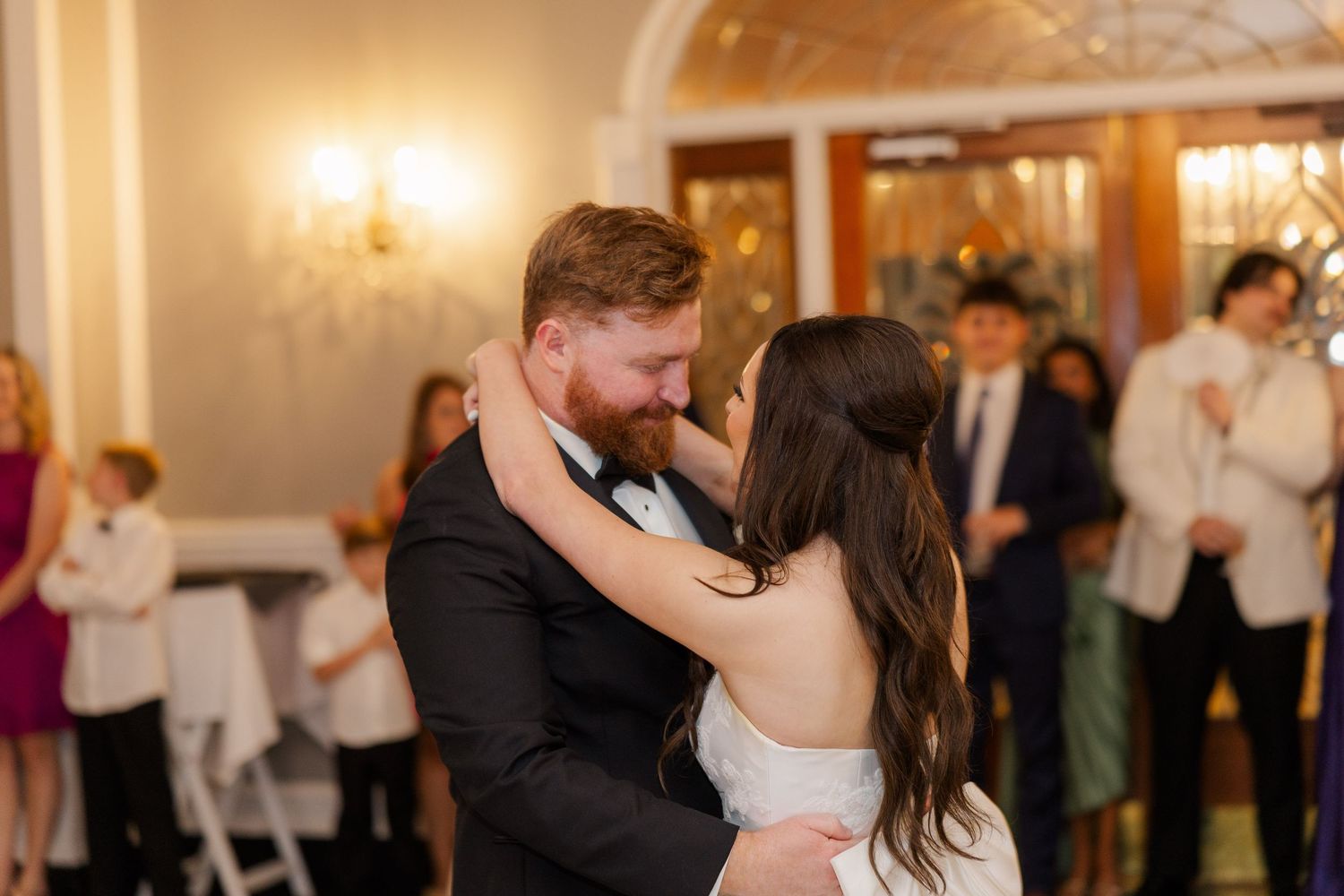 Wedding reception ballroom dance with elegant lighting and festive atmosphere.
