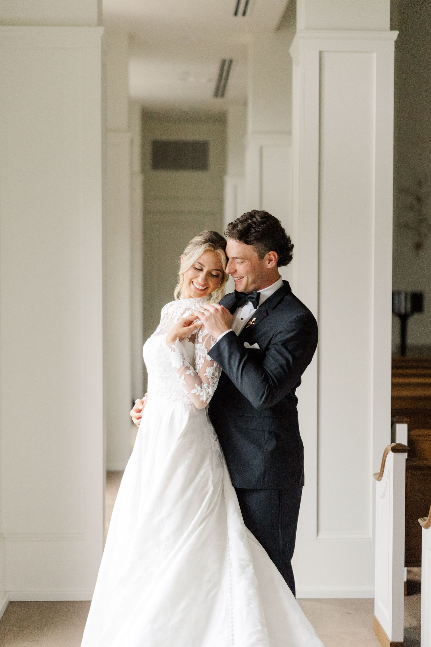 A romantic moment between newlyweds dancing together in an elegant white-columned venue.