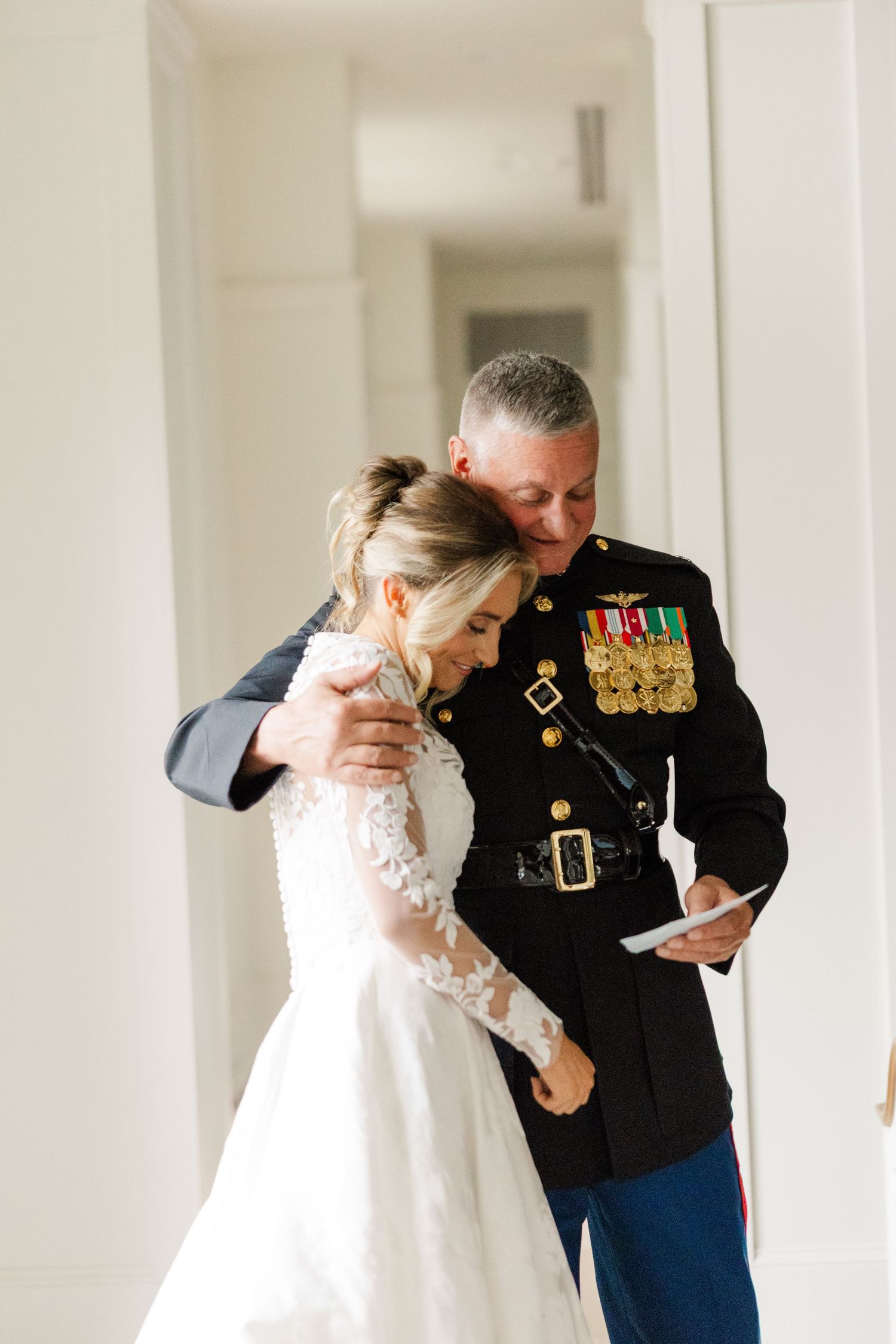 Emotional first look sequence between a bride in white and military officer in formal dress blues.