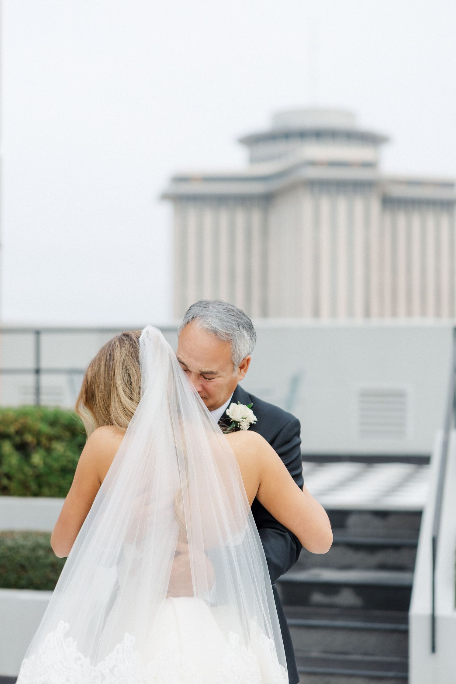 Romantic outdoor wedding moment with a couple embracing on a rooftop terrace.