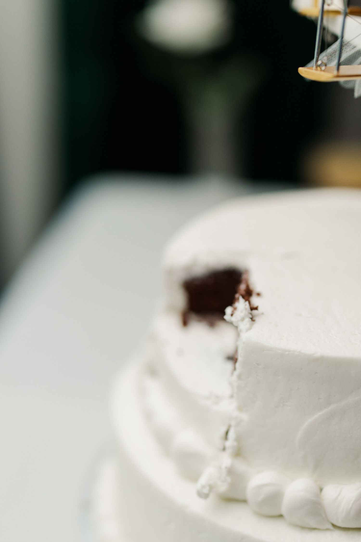 Close-up detail shot of a classic white wedding cake with smooth buttercream frosting.