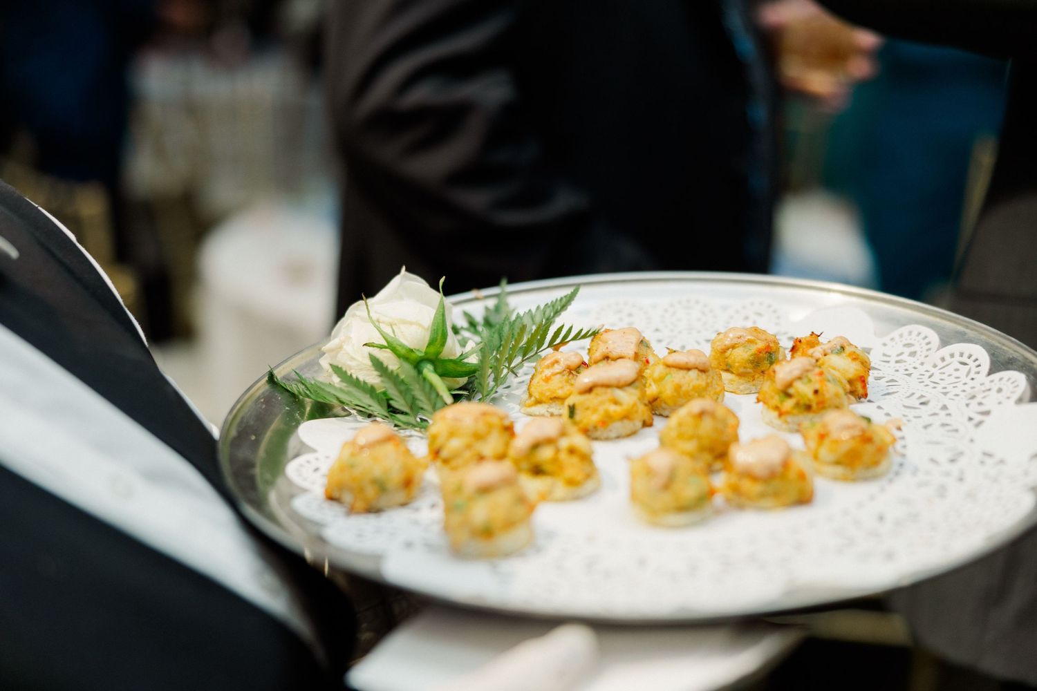 Elegant appetizers plated on white dishes with garnish.