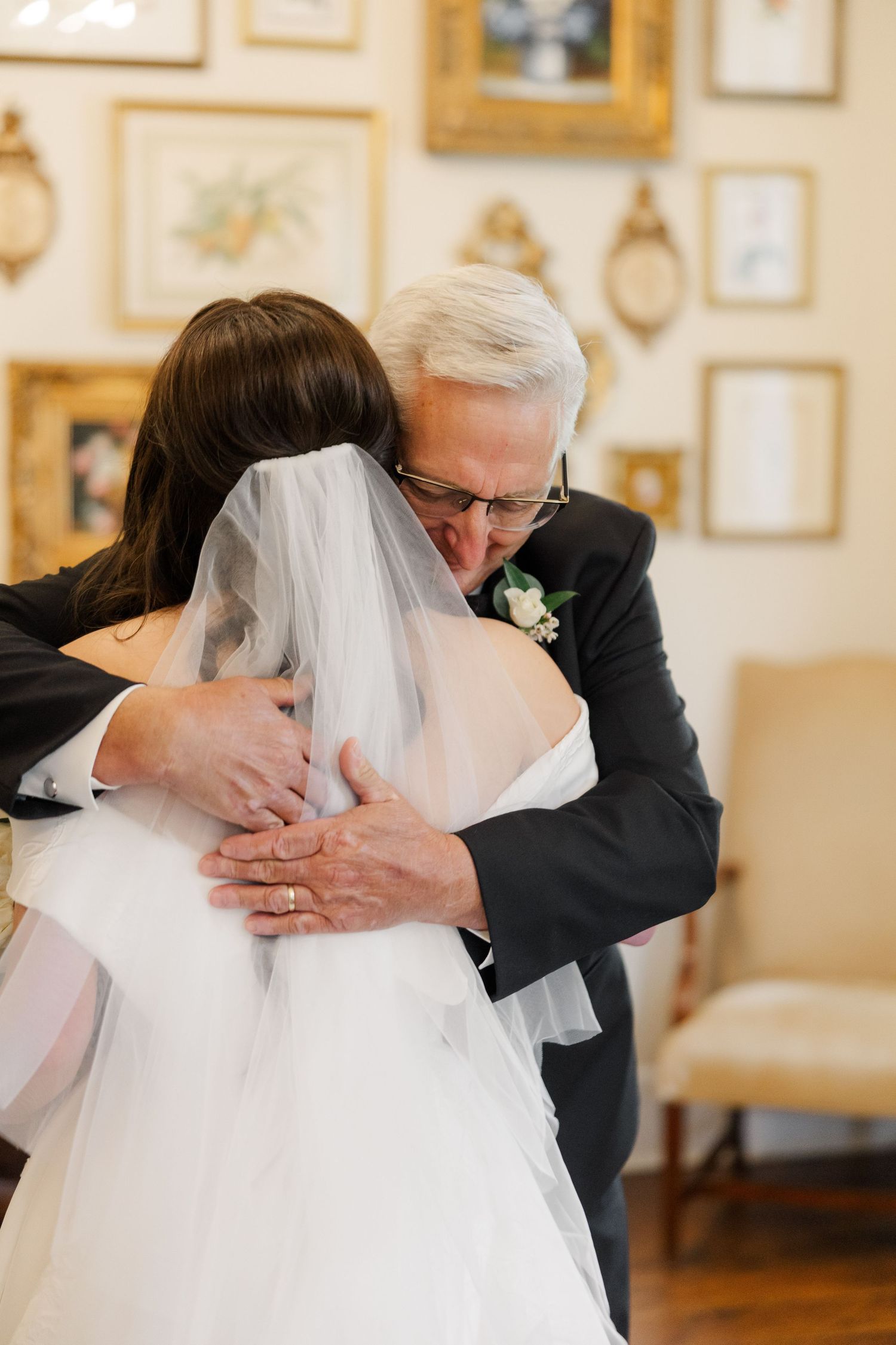 Emotional moment captured during wedding preparations with flowing white dress.