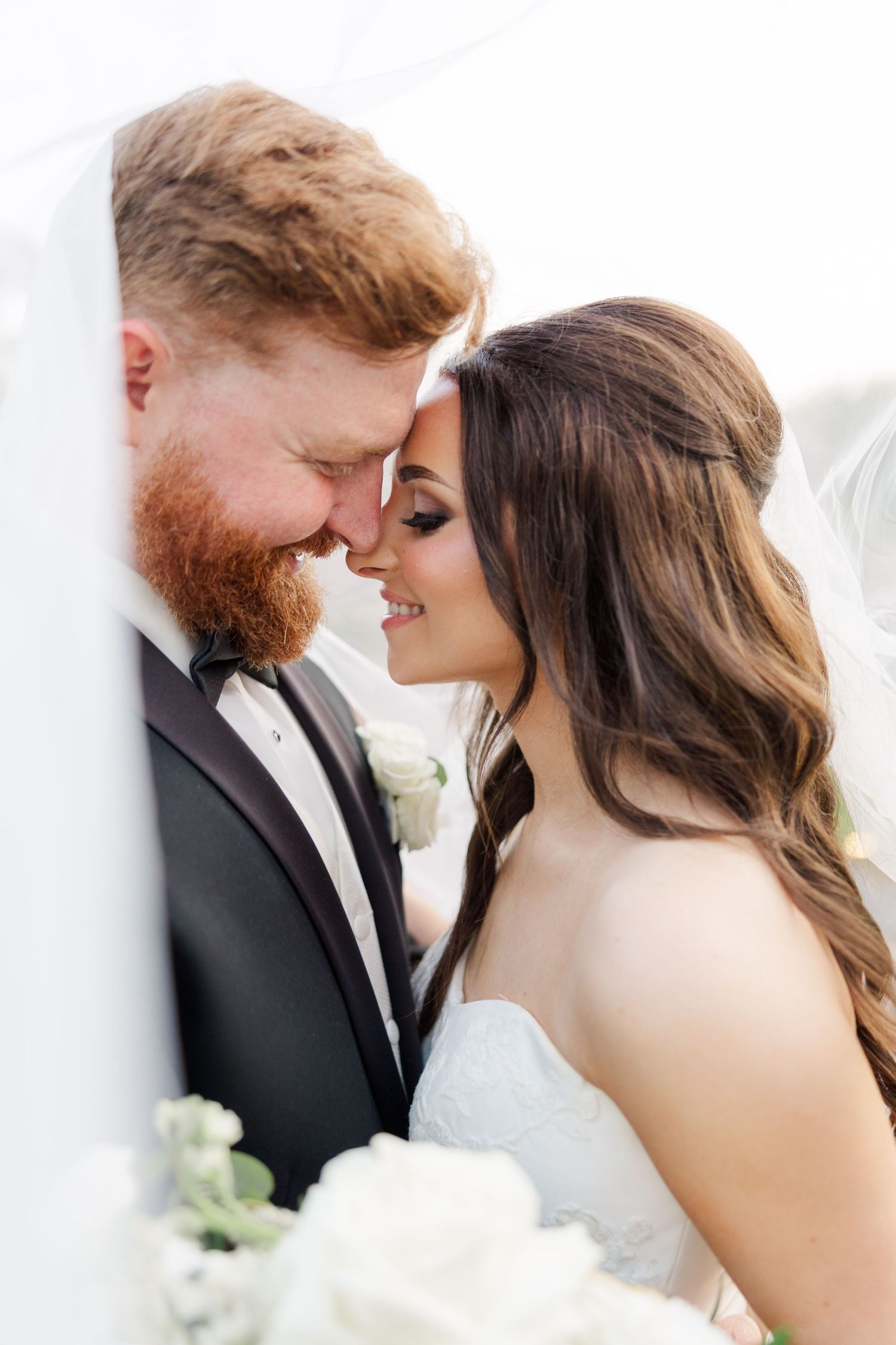 Romantic wedding portraits in soft lighting showing tender moments between newlyweds.