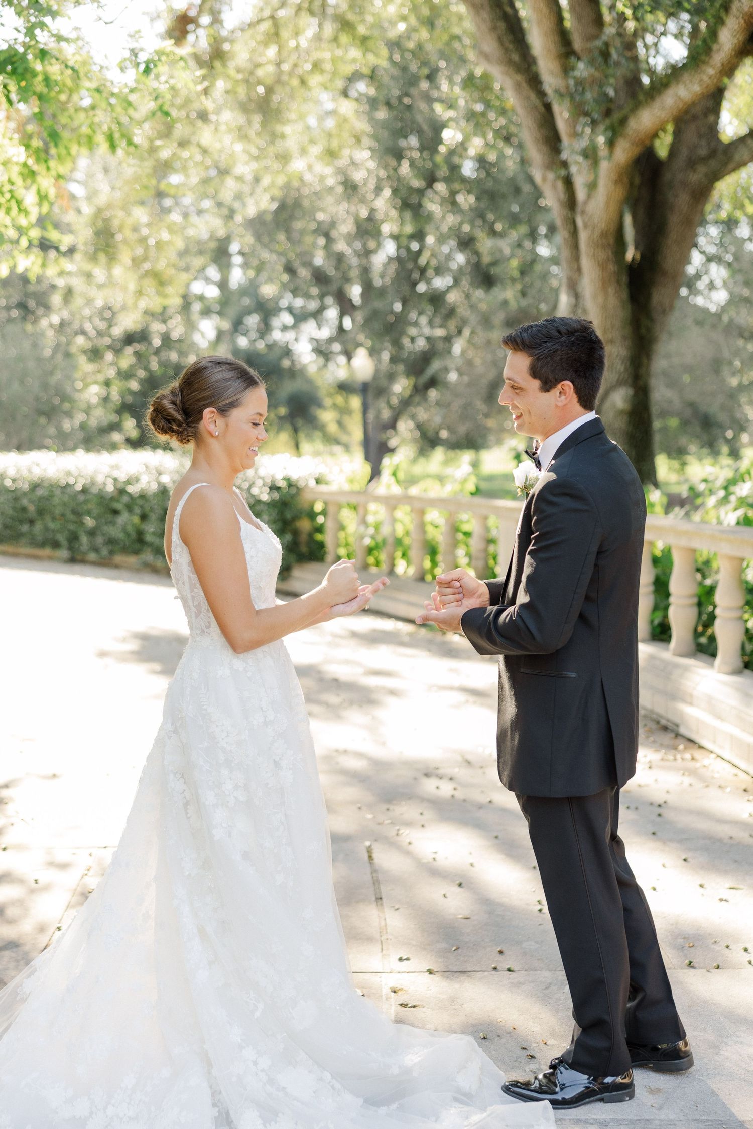Wedding couple shares playful moments on a tree-lined path during their photo session.
