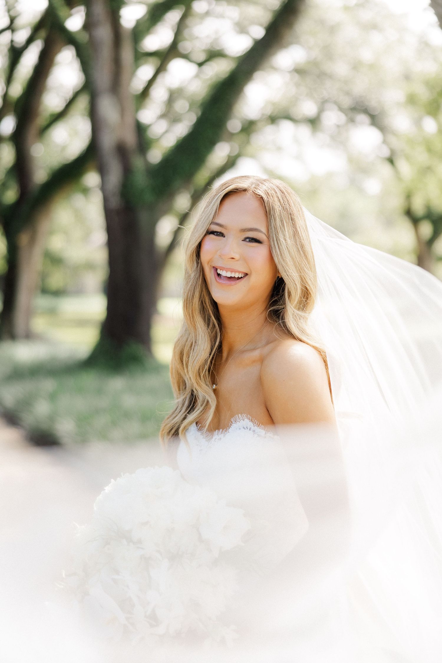 Ethereal bridal portraits captured in soft natural light under a canopy of oak trees.