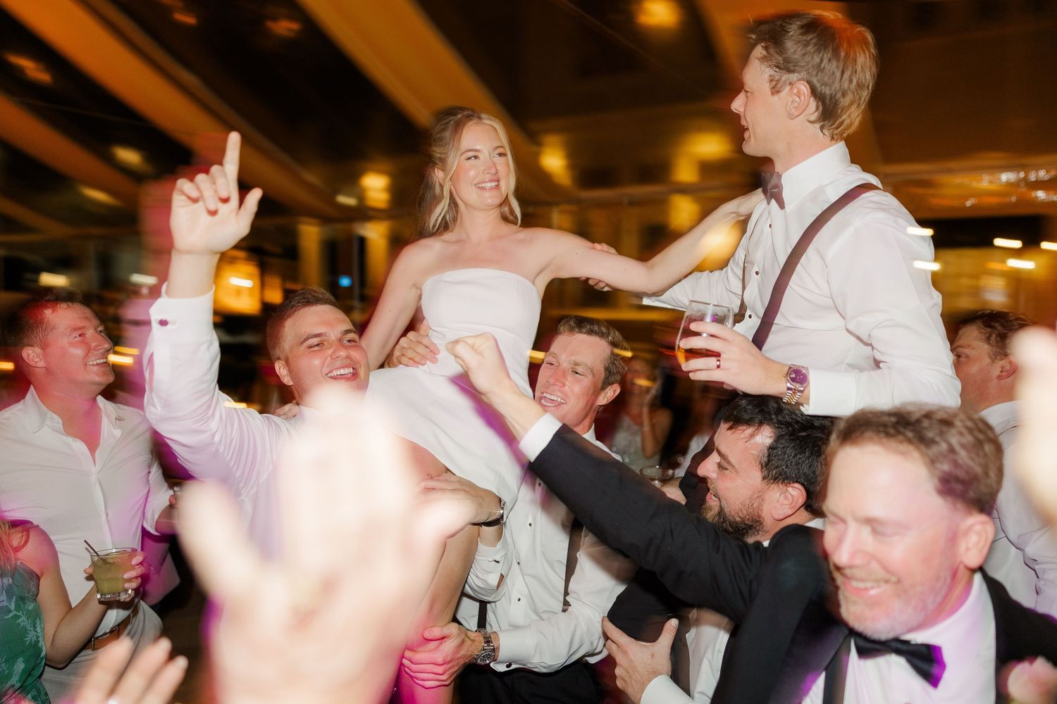 Energetic wedding reception dance party with guests celebrating on a crowded dance floor.