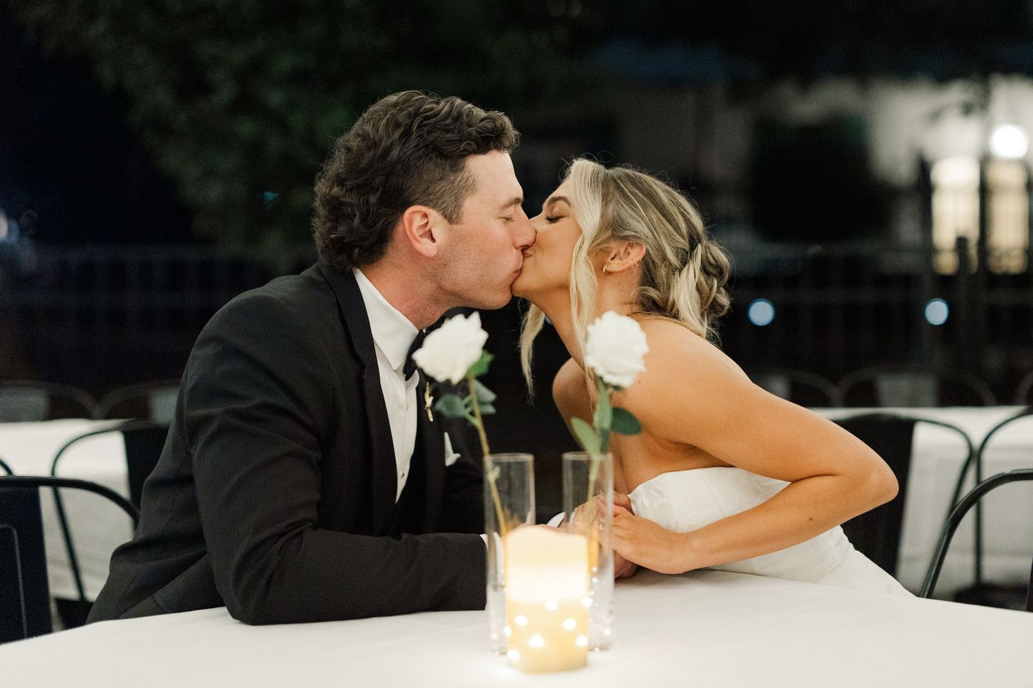 Romantic candlelit moment between newlyweds at evening reception.
