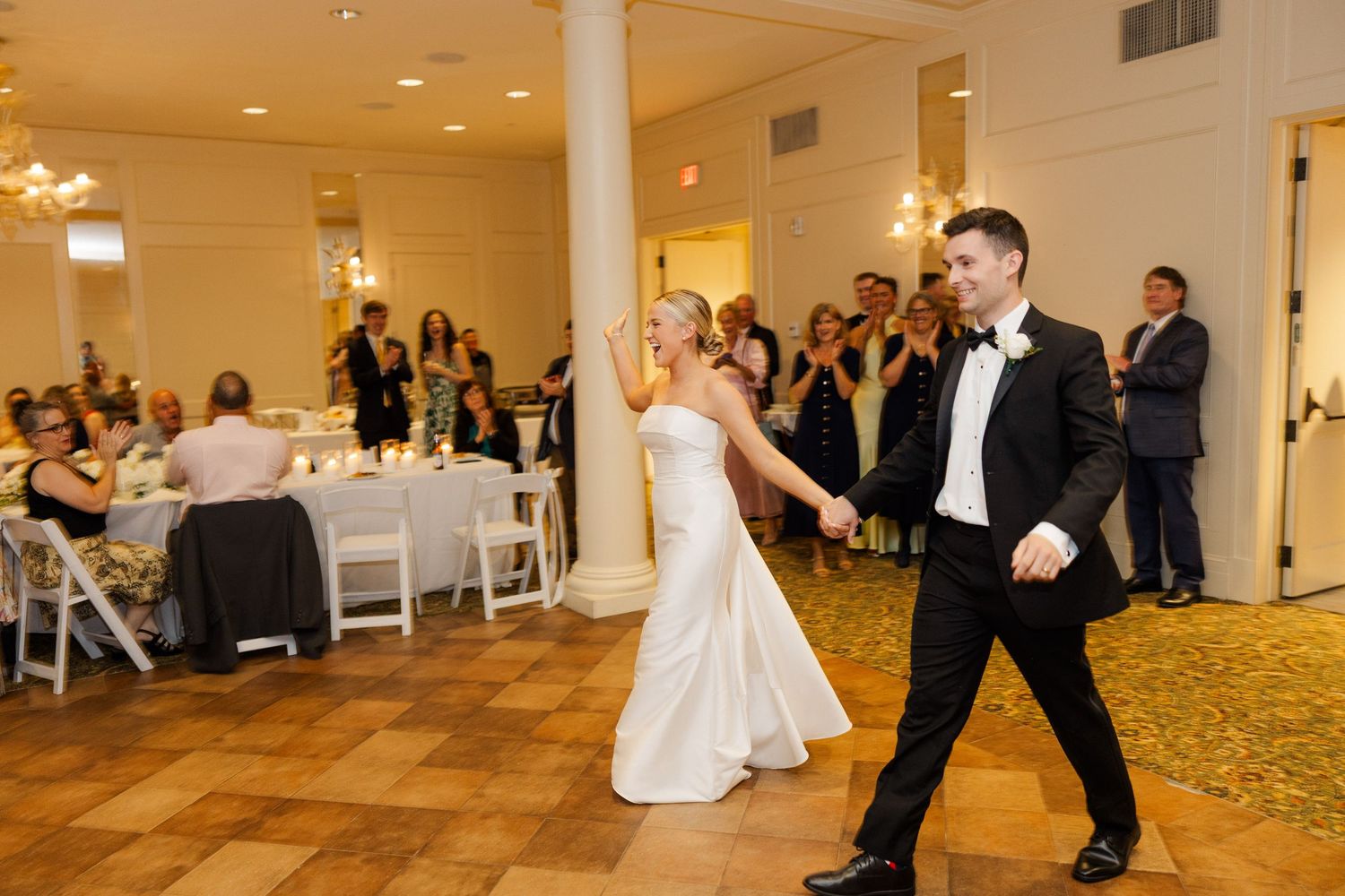 Elegant ballroom dance floor with guests watching a special moment during a wedding reception.