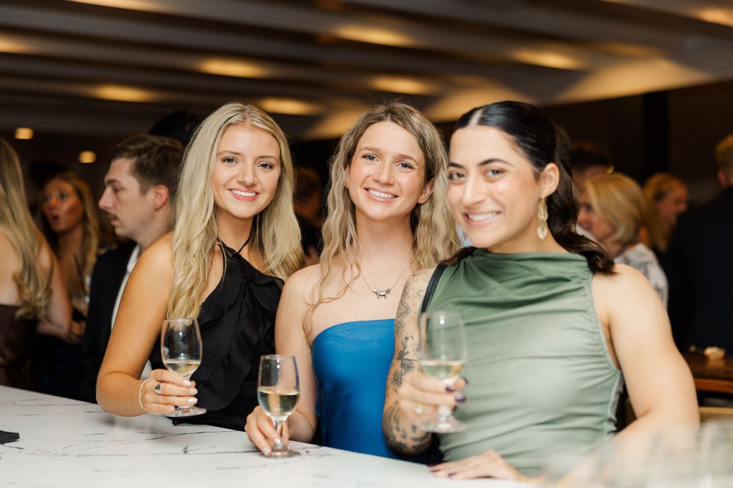 Wedding reception guests enjoying drinks and conversation at an evening celebration.