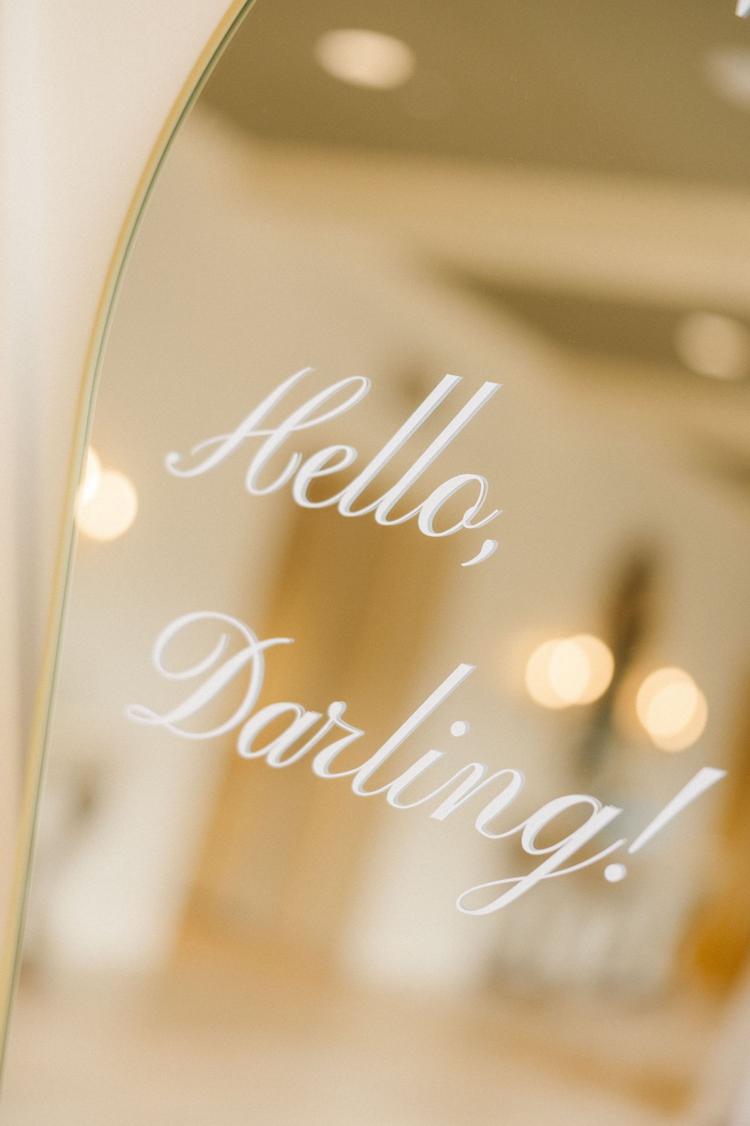 Elegant wedding signage with cursive text reading 'Hello Darling' displayed in soft bokeh lighting.