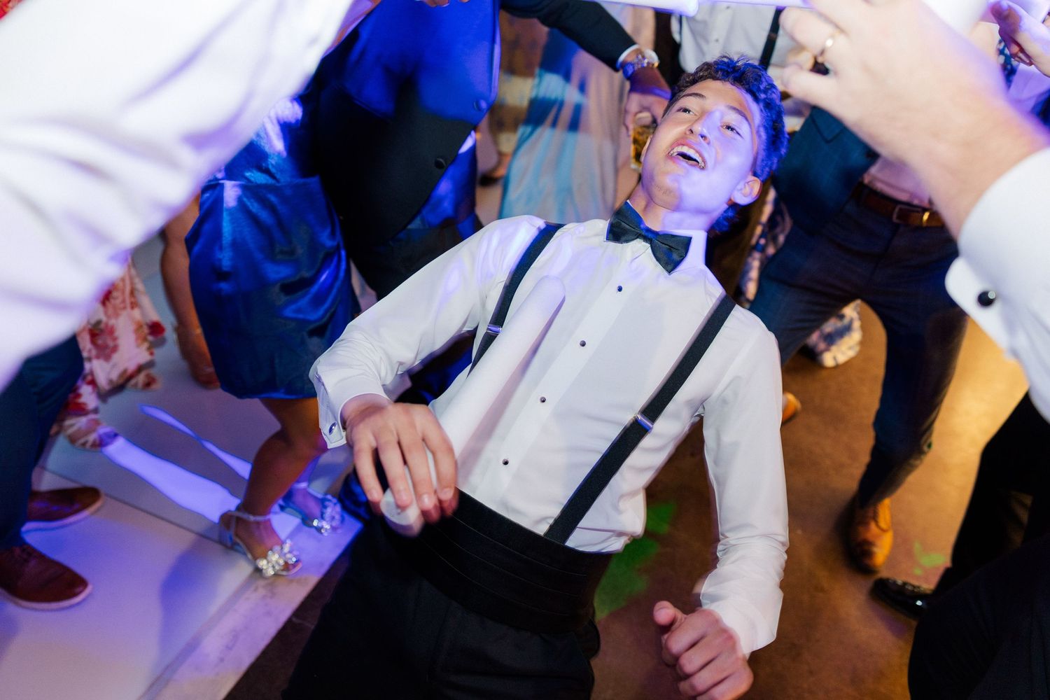 A lively wedding reception moment with dancing and celebration in dynamic lighting.