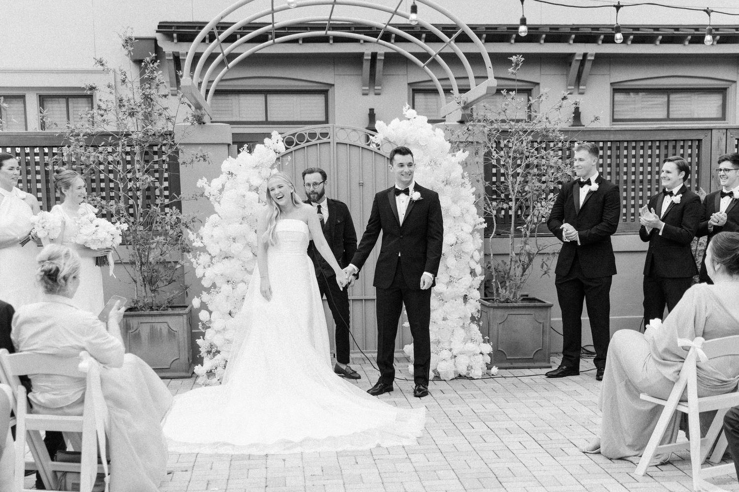 Wedding reception setup with elegant white decor and floral arrangements.