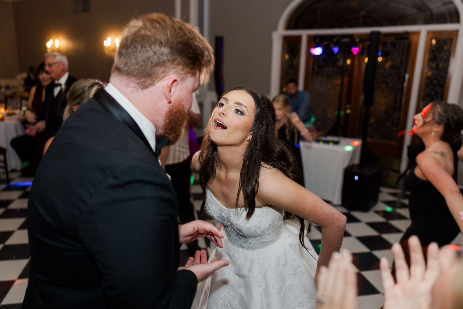 Wedding reception dance floor moments with guests celebrating in a ballroom setting.