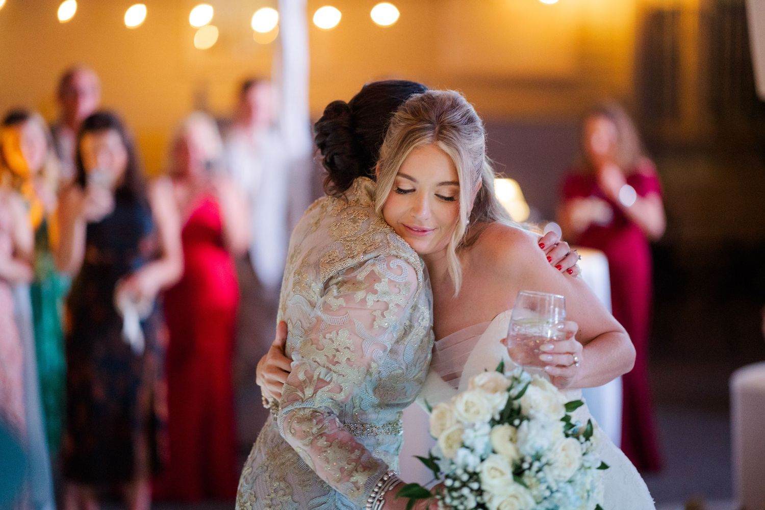 Wedding reception scene with warm lighting and floral arrangements.