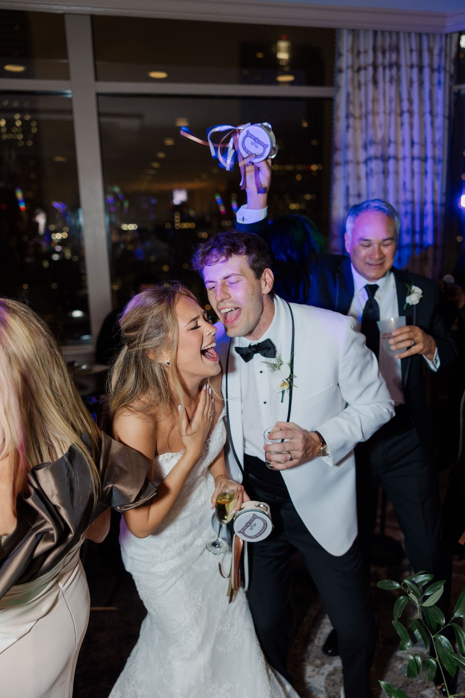Lively wedding reception dance party with guests in formal attire.