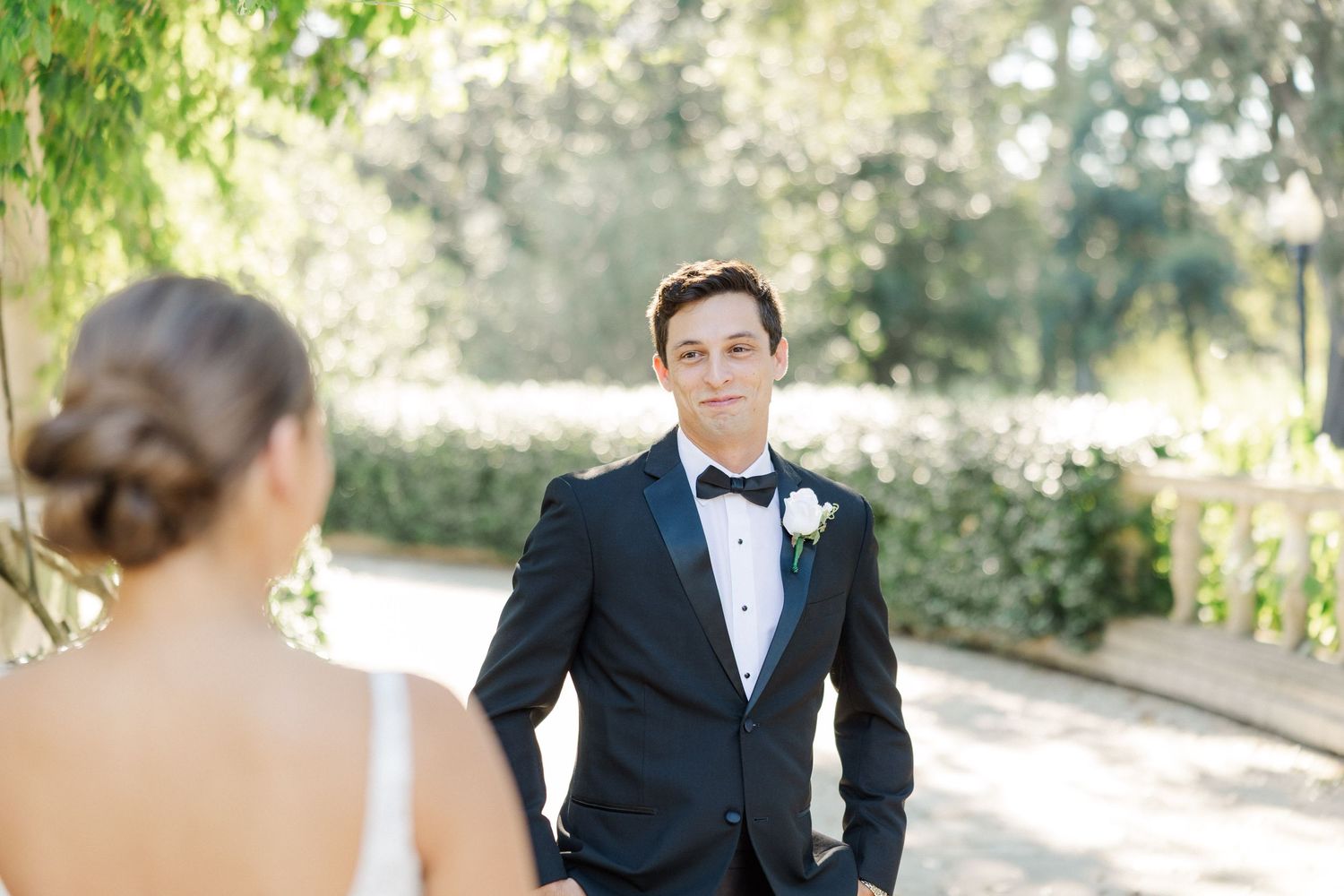 A couple shares a romantic moment in an outdoor garden setting during a wedding photoshoot.
